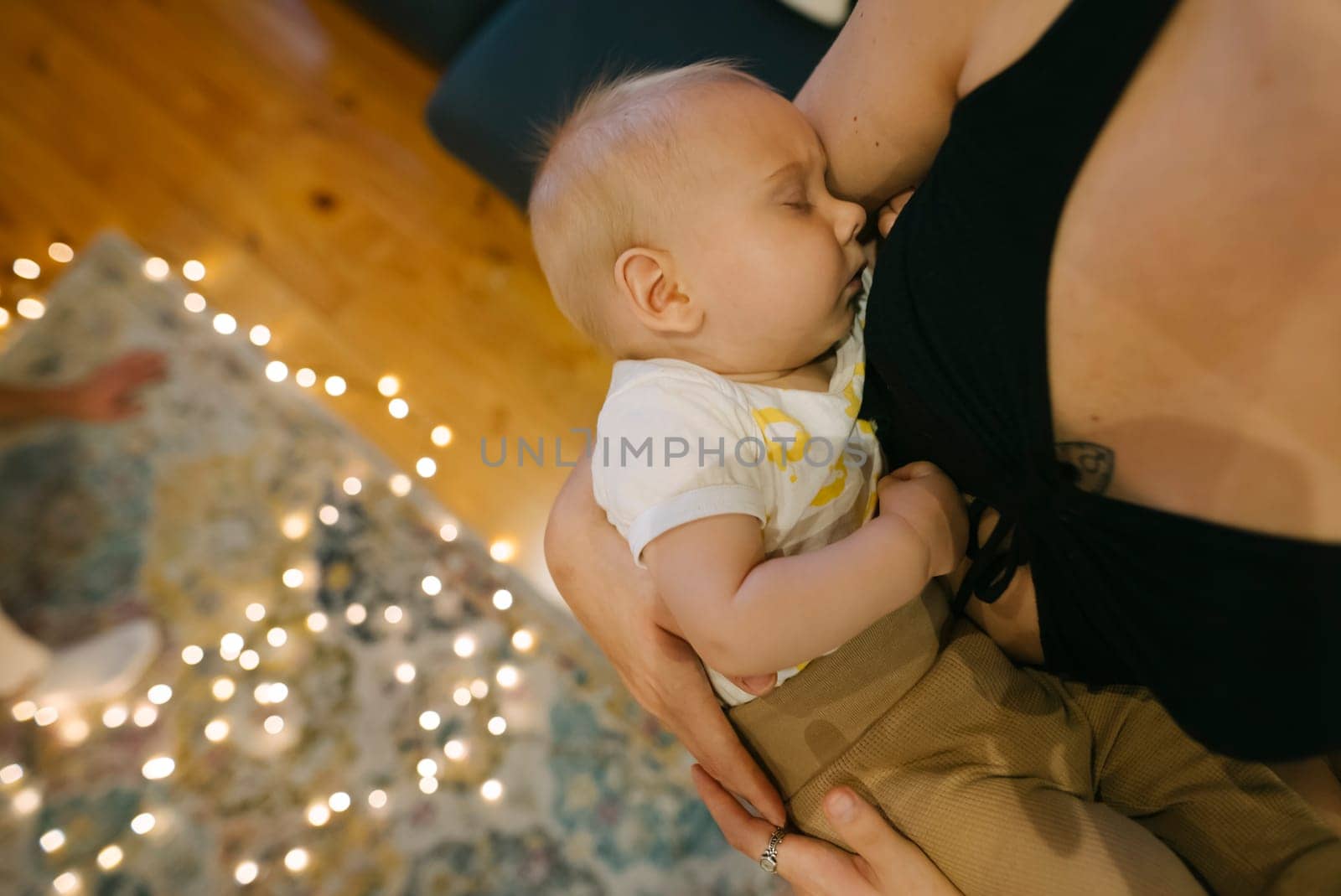 In a serene and peaceful scene, a loving mother cradles her sleeping baby, enveloped in soft lights and warmth