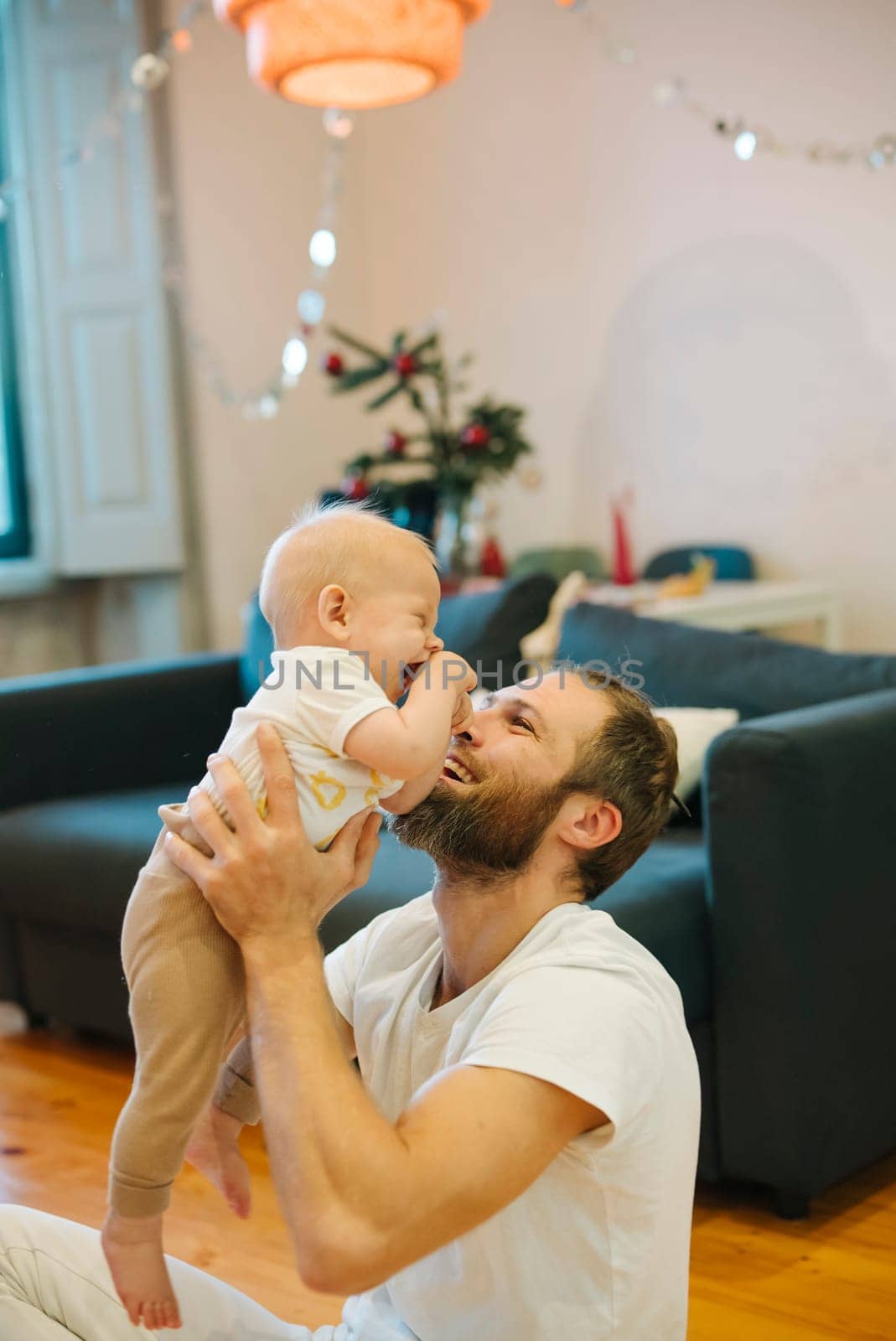 A truly heartwarming and delightful scene of a father joyfully and playfully engaging with his baby at home