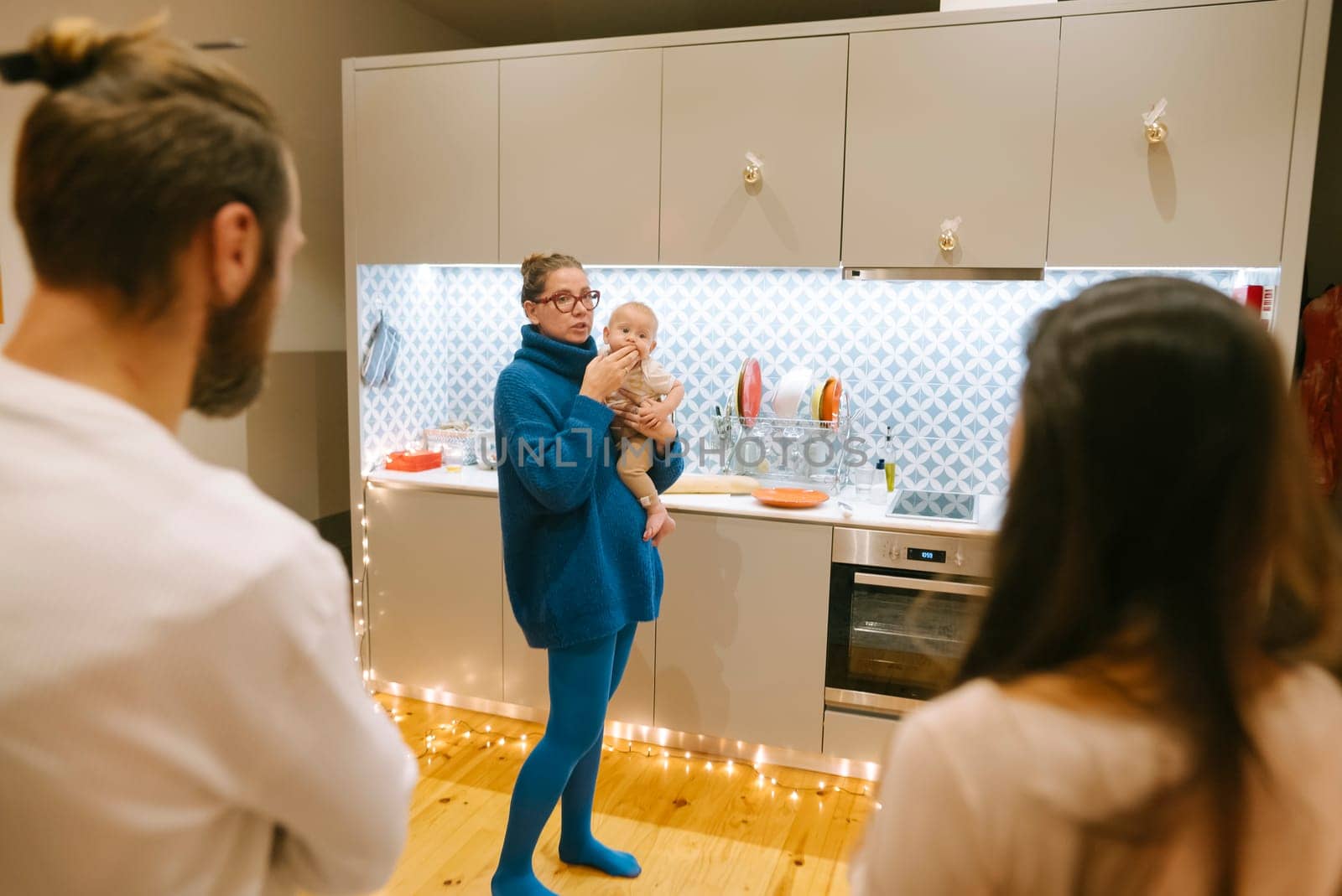 A cherished warm moment of family bonding takes place with a baby in a stylish and inviting kitchen setting