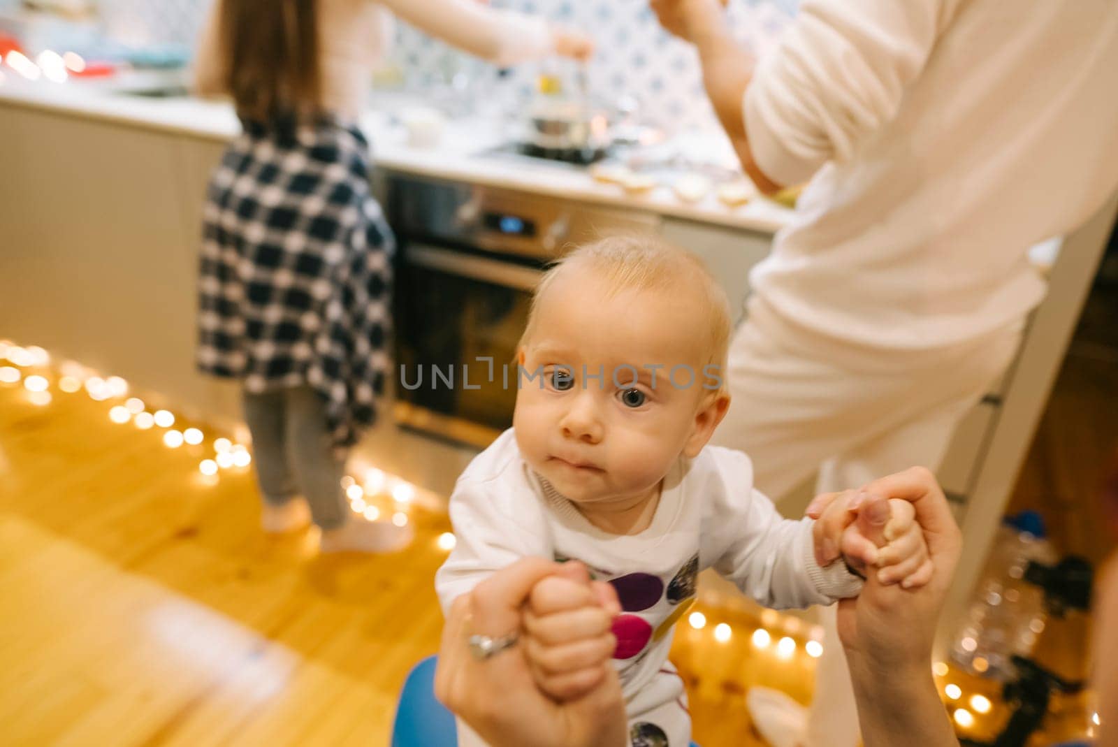 A sweet baby rests in a loving caregivers arms in a joyful kitchen filled with laughter, creating memories