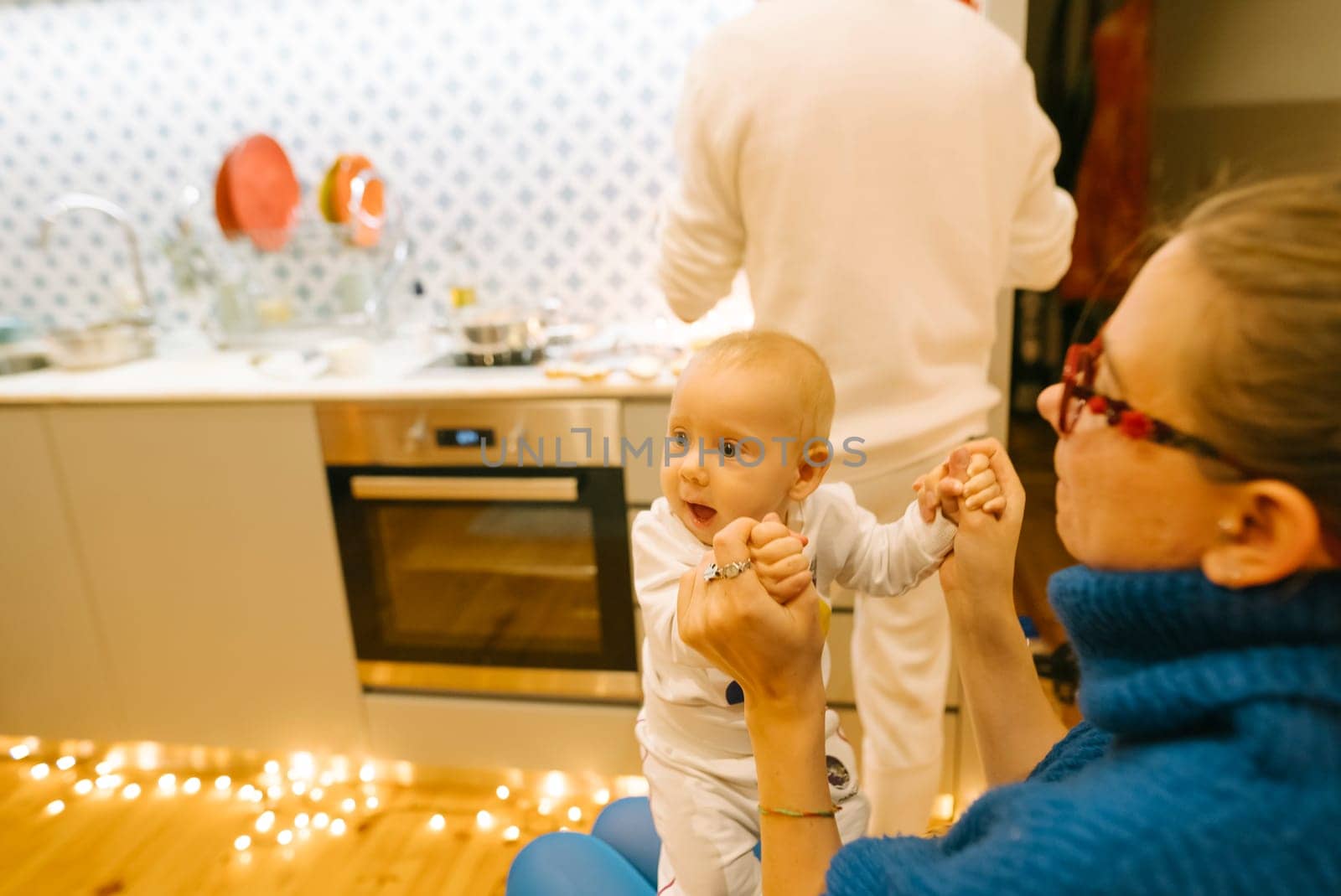 A heartwarming scene of a baby and caregiver joyfully sharing a delightful moment in a festive, cheerful kitchen