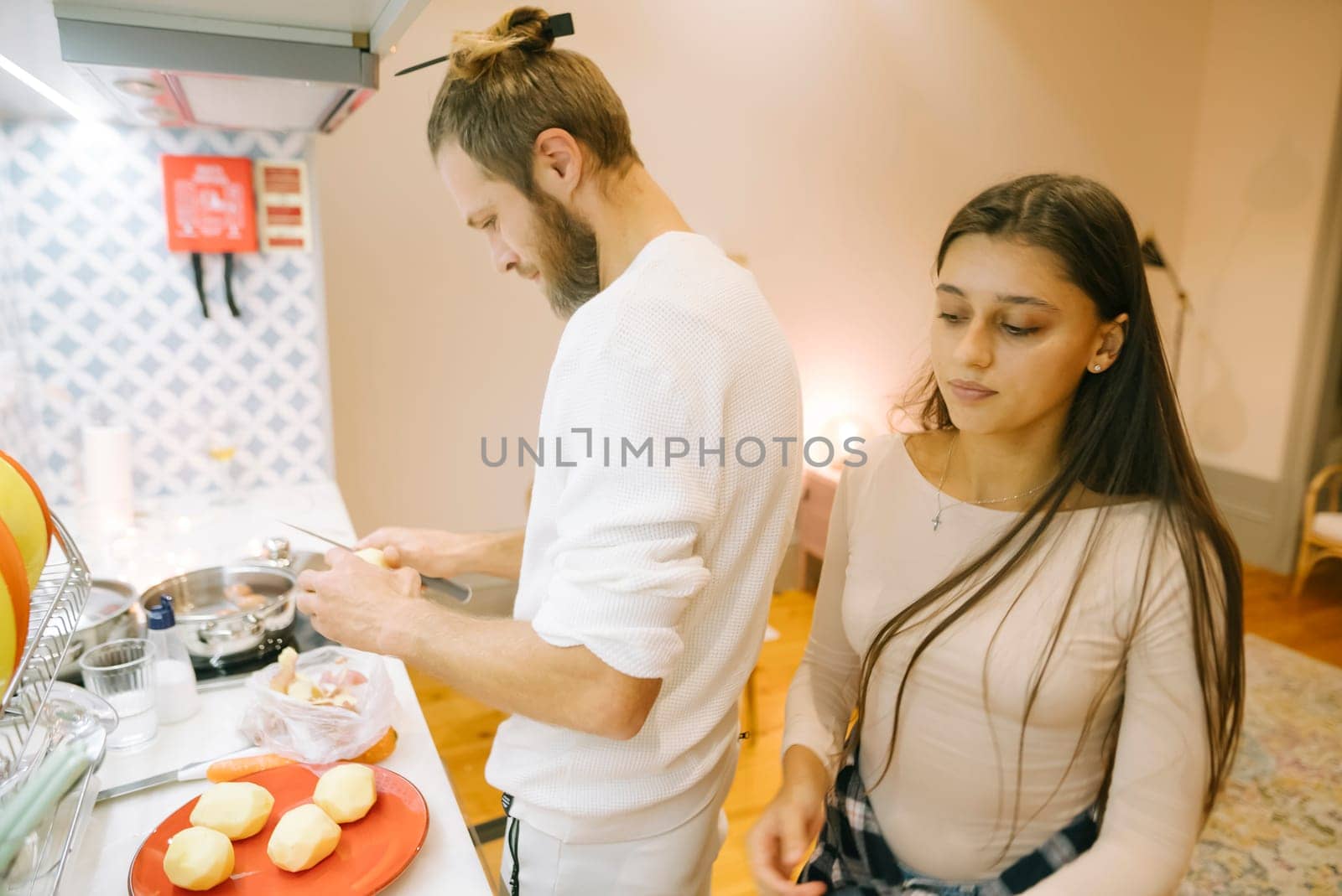 A couple joyfully enjoying their quality time while cooking delicious meals together in a stylish kitchen setting