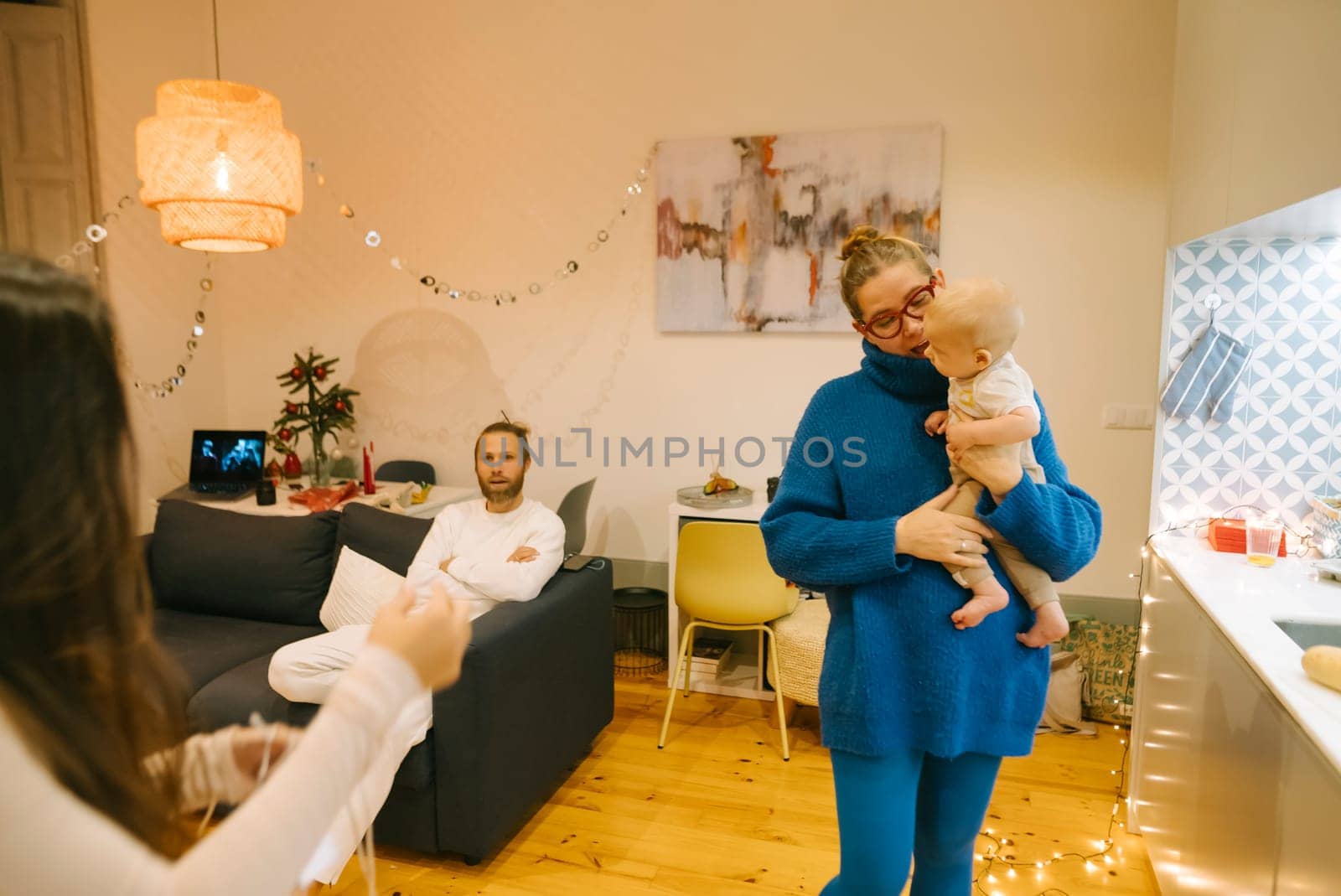 A heartwarming family moment captured in a cozy room, with a loving woman gently holding a tiny baby close