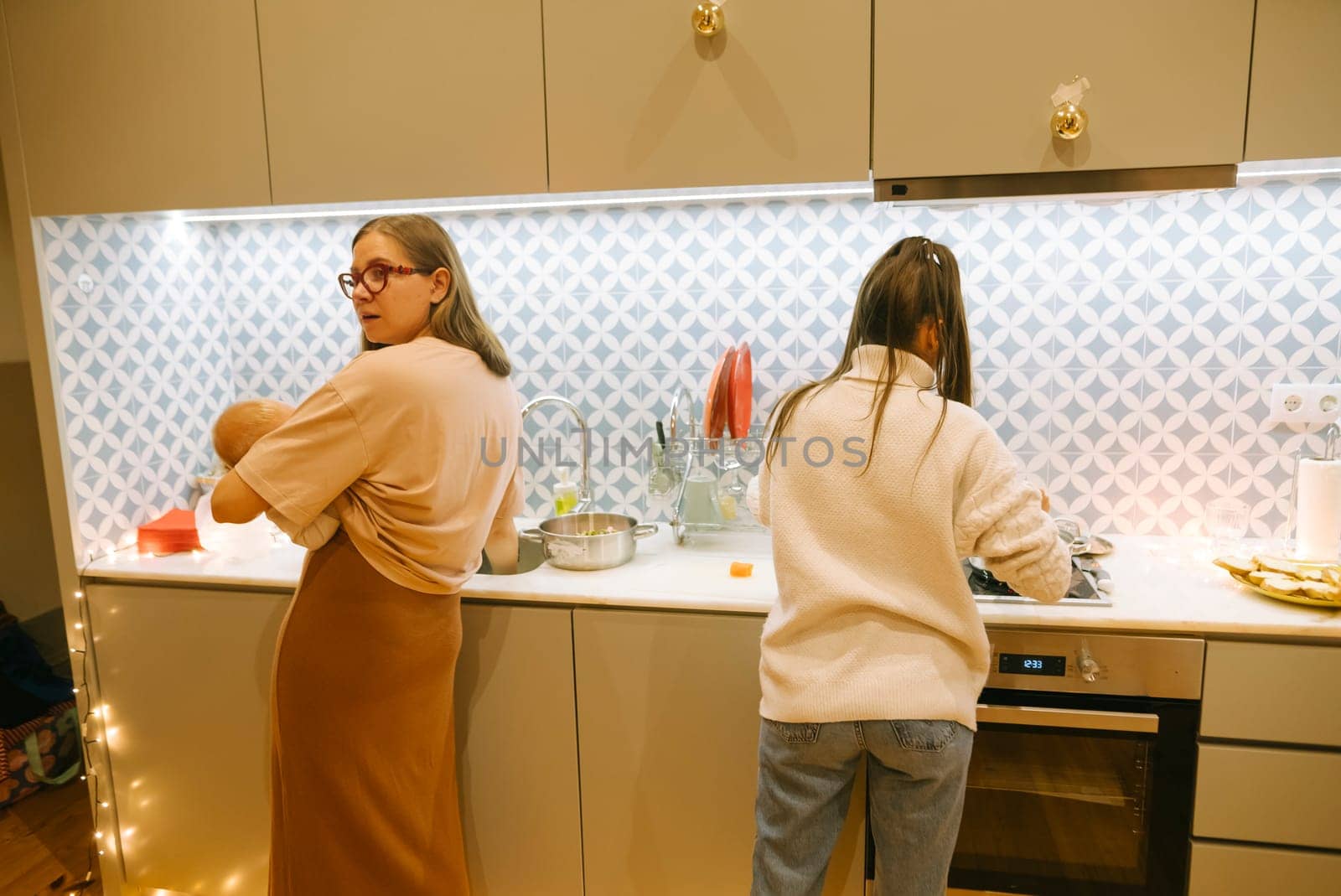 In a stylish kitchen, two women cook together, blending domestic harmony with modern design elements
