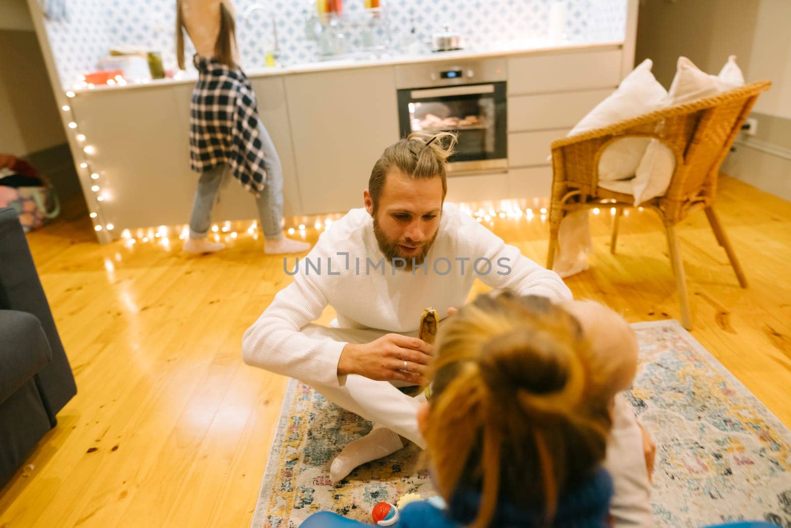 A delightful and joyful moment of family interaction occurs in a cozy, stylish living space adorned with warm lighting
