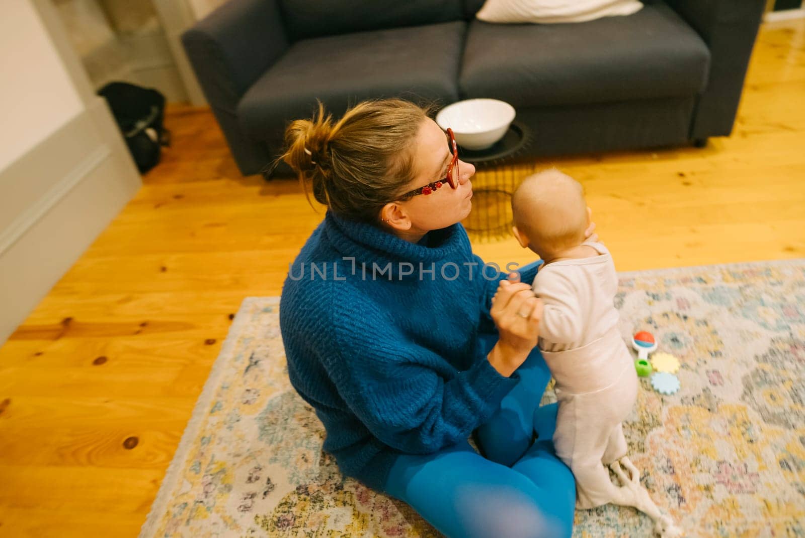 In a cozy living room setting, there is a loving and tender interaction between a caring parent and their baby