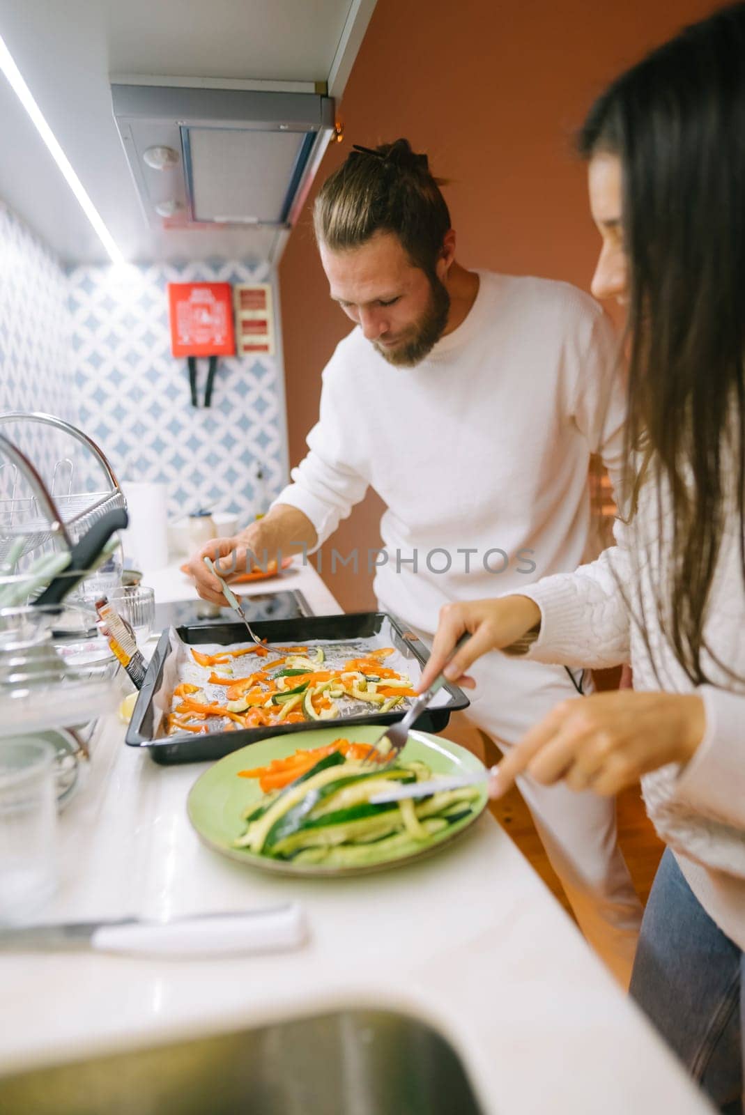 A delightful and heartwarming moment of a loving couple joyfully preparing healthy meals together in a cozy kitchen