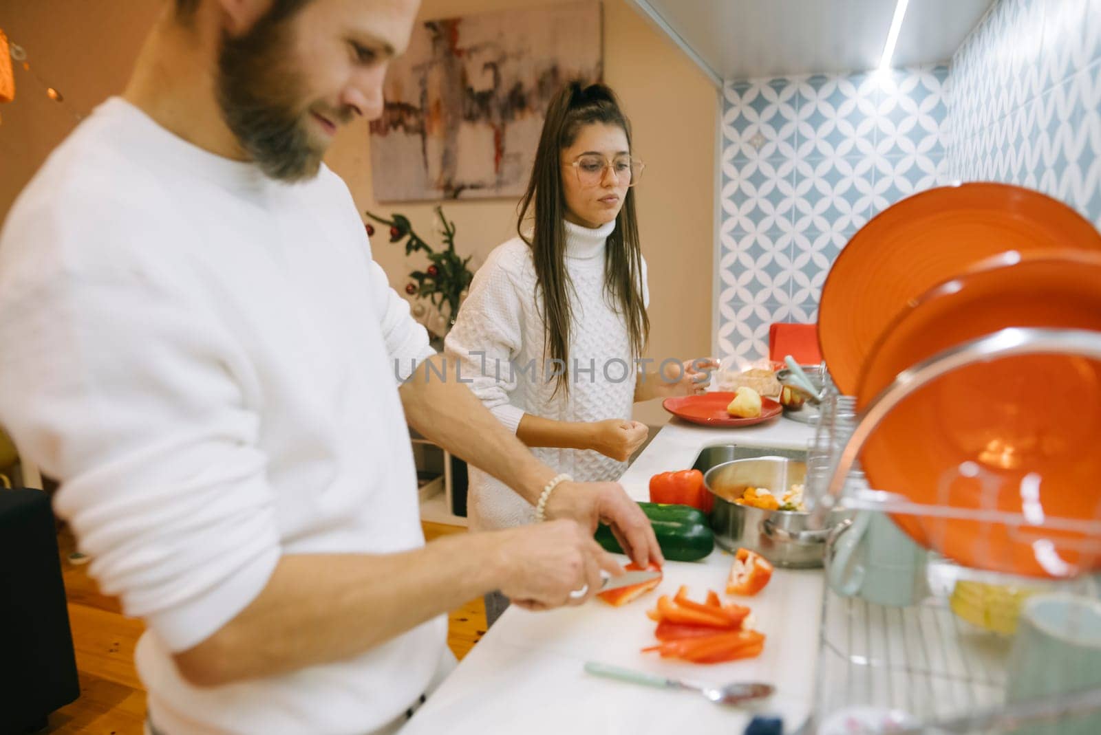 A couple joyfully prepares fresh vegetables in their modern kitchen, enjoying quality time together