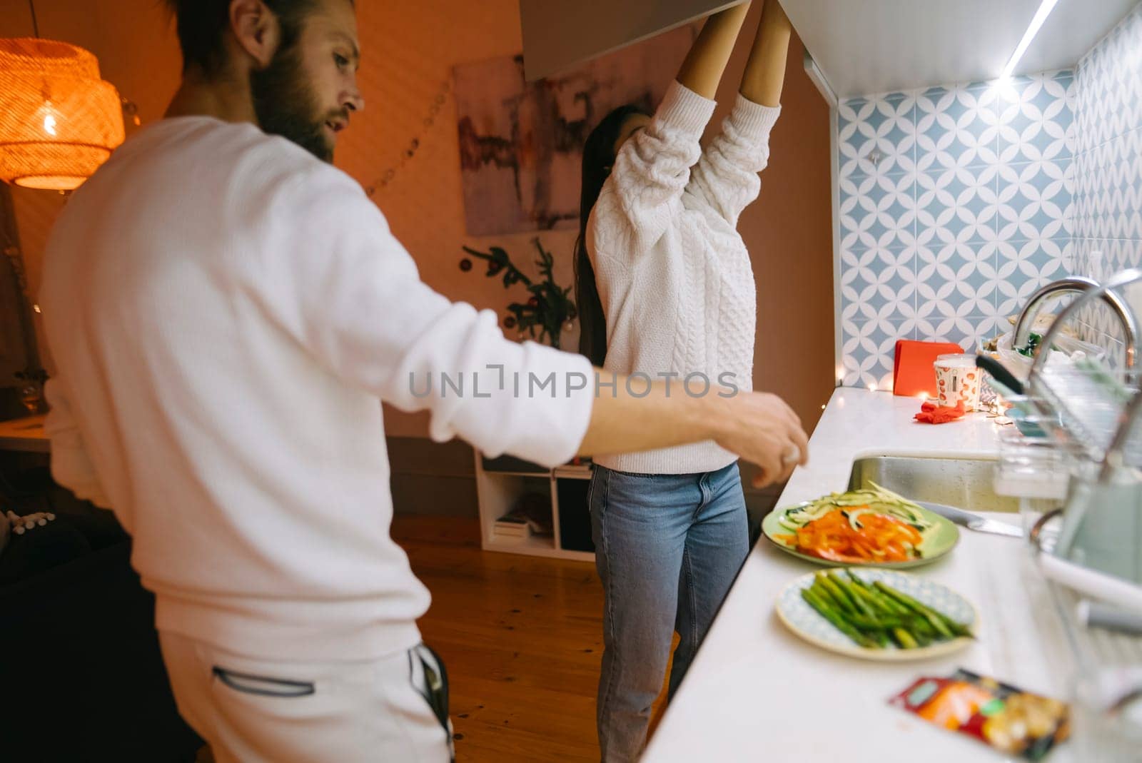 A loving couple is sharing their quality cooking time together in a cozy and inviting kitchen space
