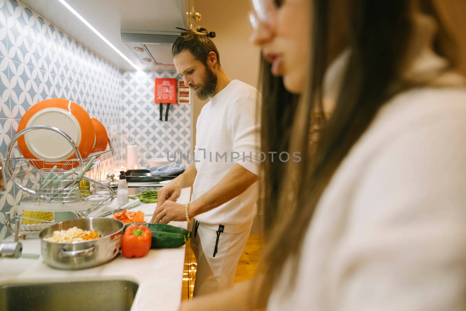 A couple is preparing a variety of fresh ingredients for a meal in their stylish and modern kitchen space