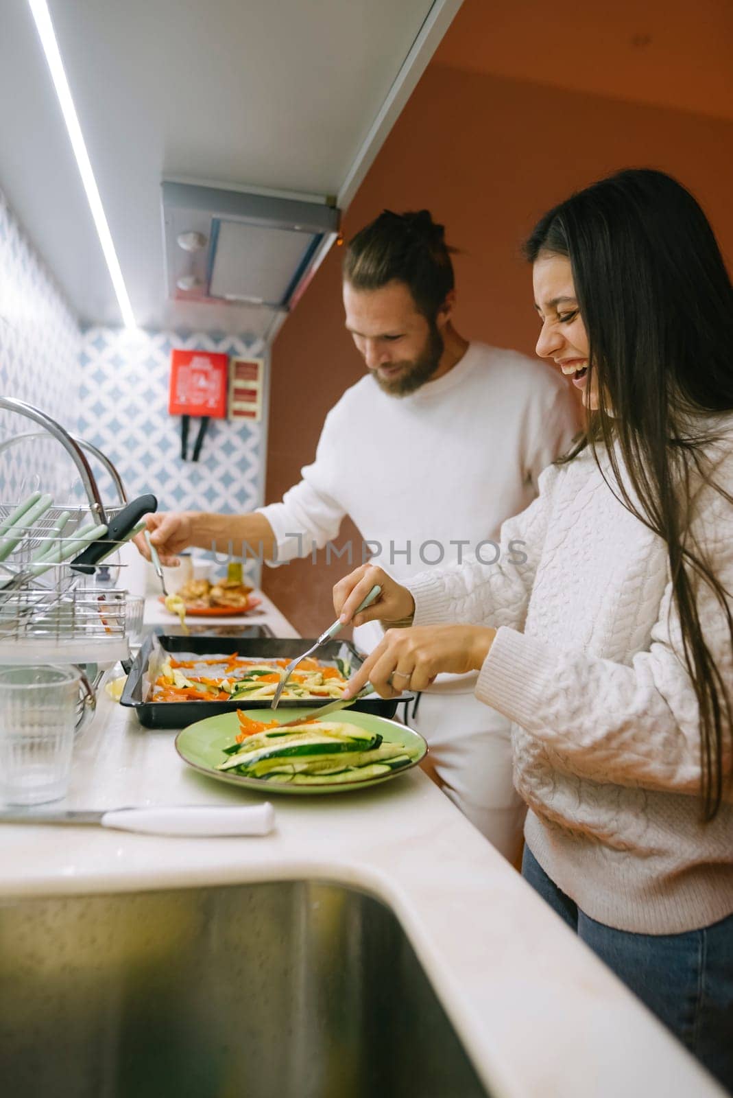A joyful couple happily prepares a delicious meal together, showcasing love, collaboration, and creativity in cooking