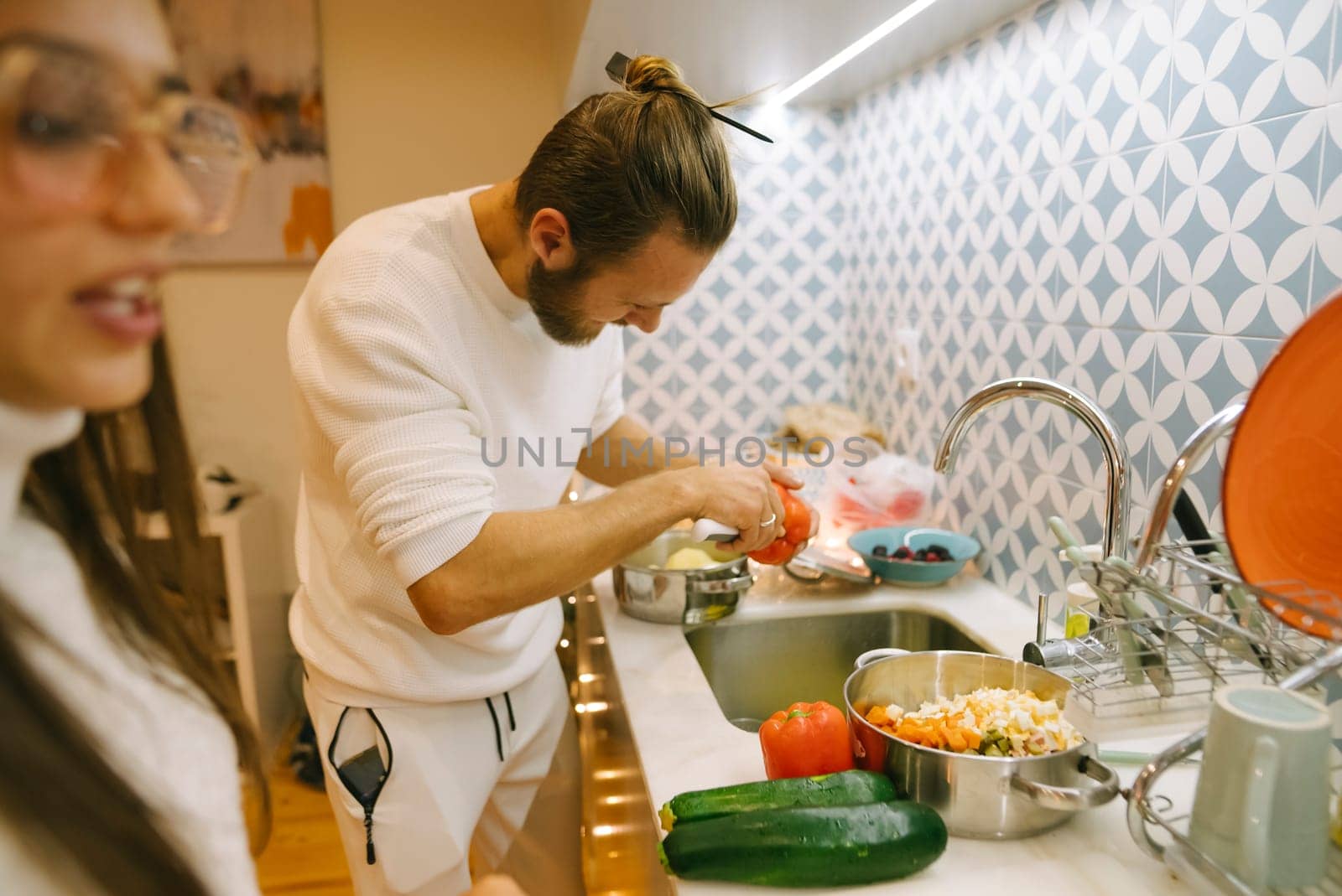 A lovely couple enjoying a fun cooking moment together, showcasing vibrant fresh ingredients in a stylish kitchen