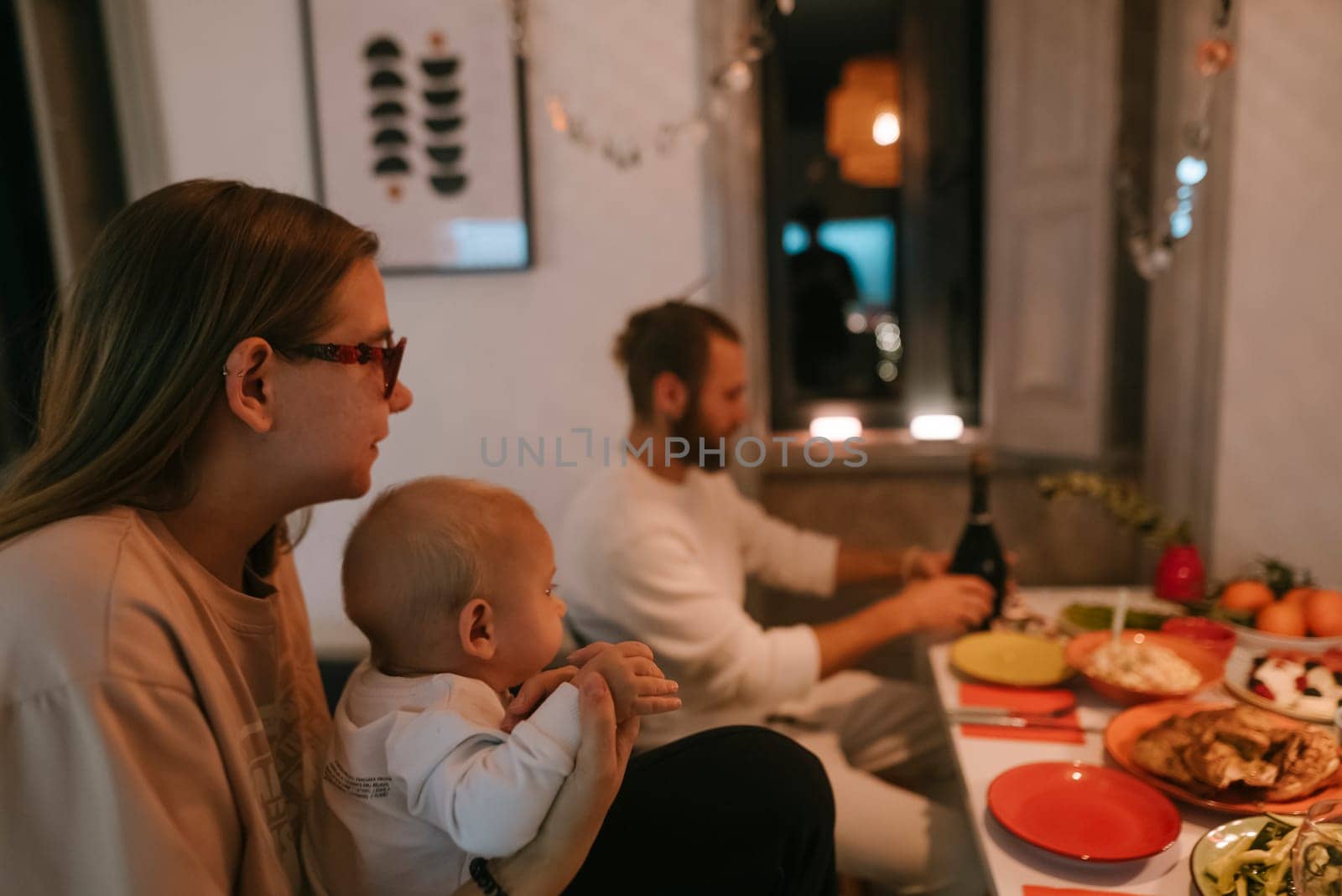 A warm family dinner scene of a loving couple with their baby enjoying a delightful meal at the table