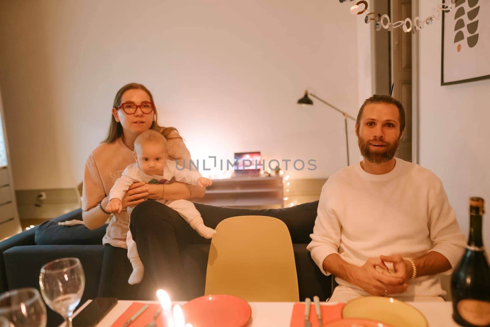 A delightful and cozy family dinner setting showcasing a woman, a man, and their cherished baby enjoying time together