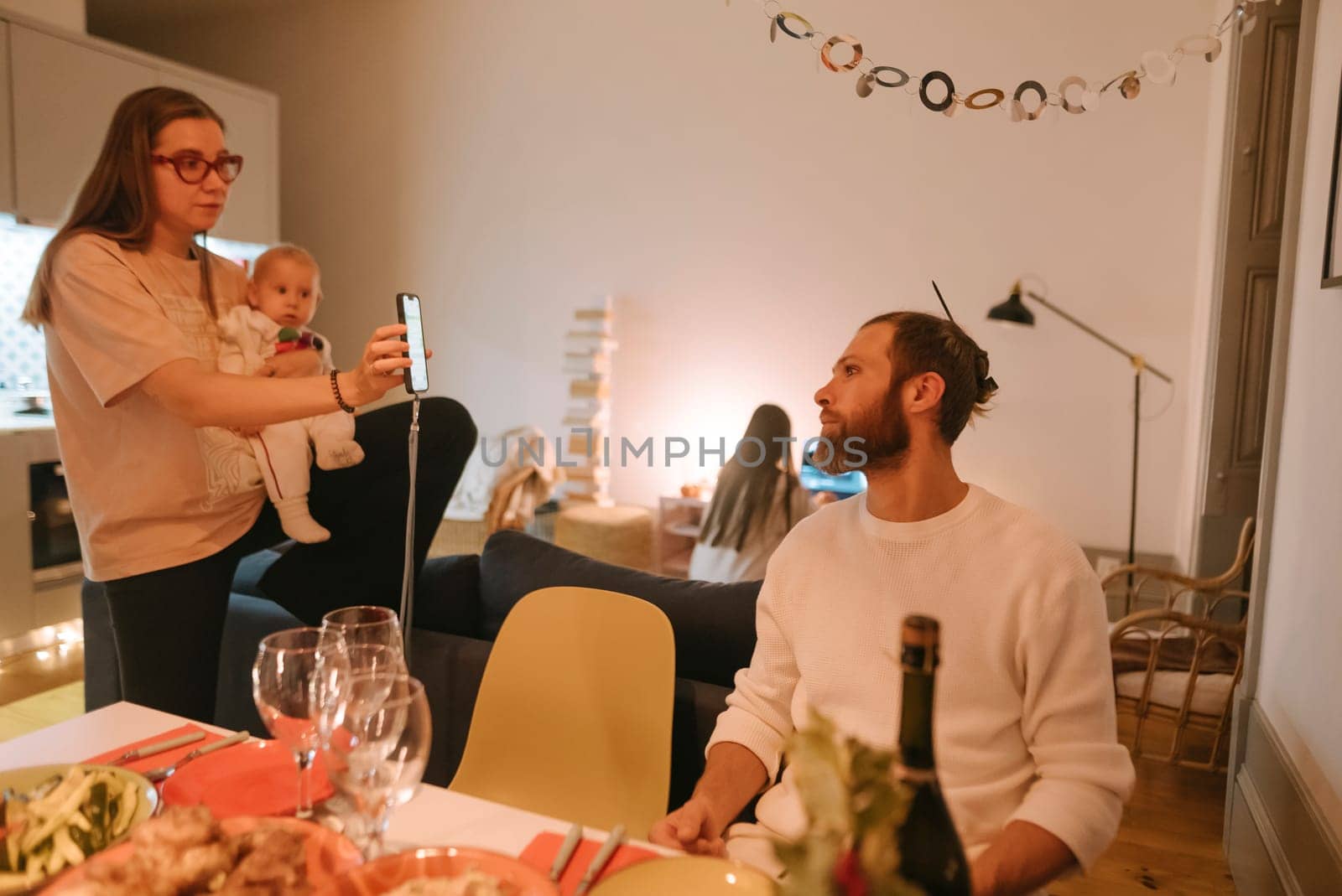 A warm and cozy family scene featuring a delightful baby, relishing a festive dinner in a modern and inviting setting