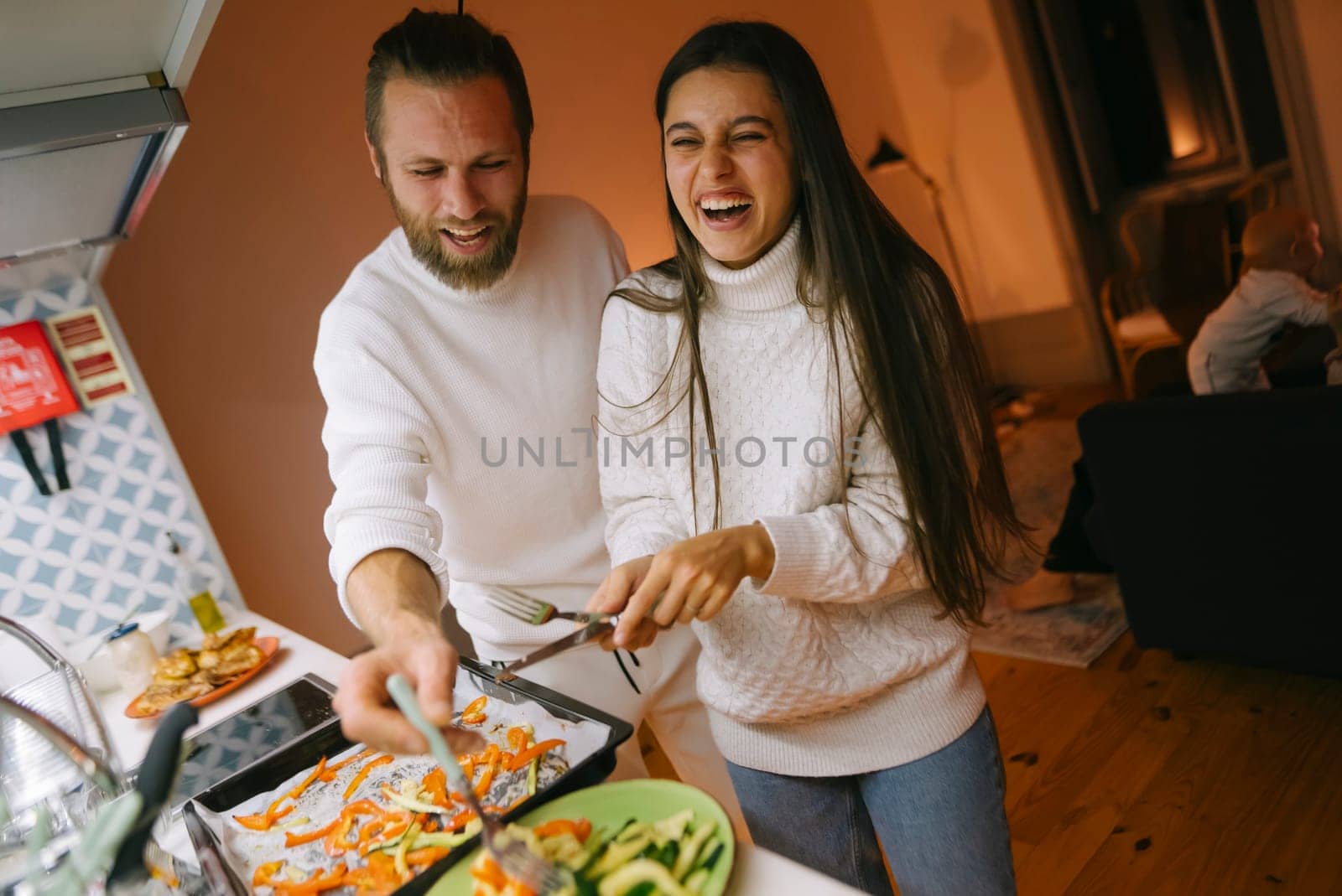 In a warm and cozy kitchen, a joyful couple engages in cooking together, sharing laughter and creative culinary moments