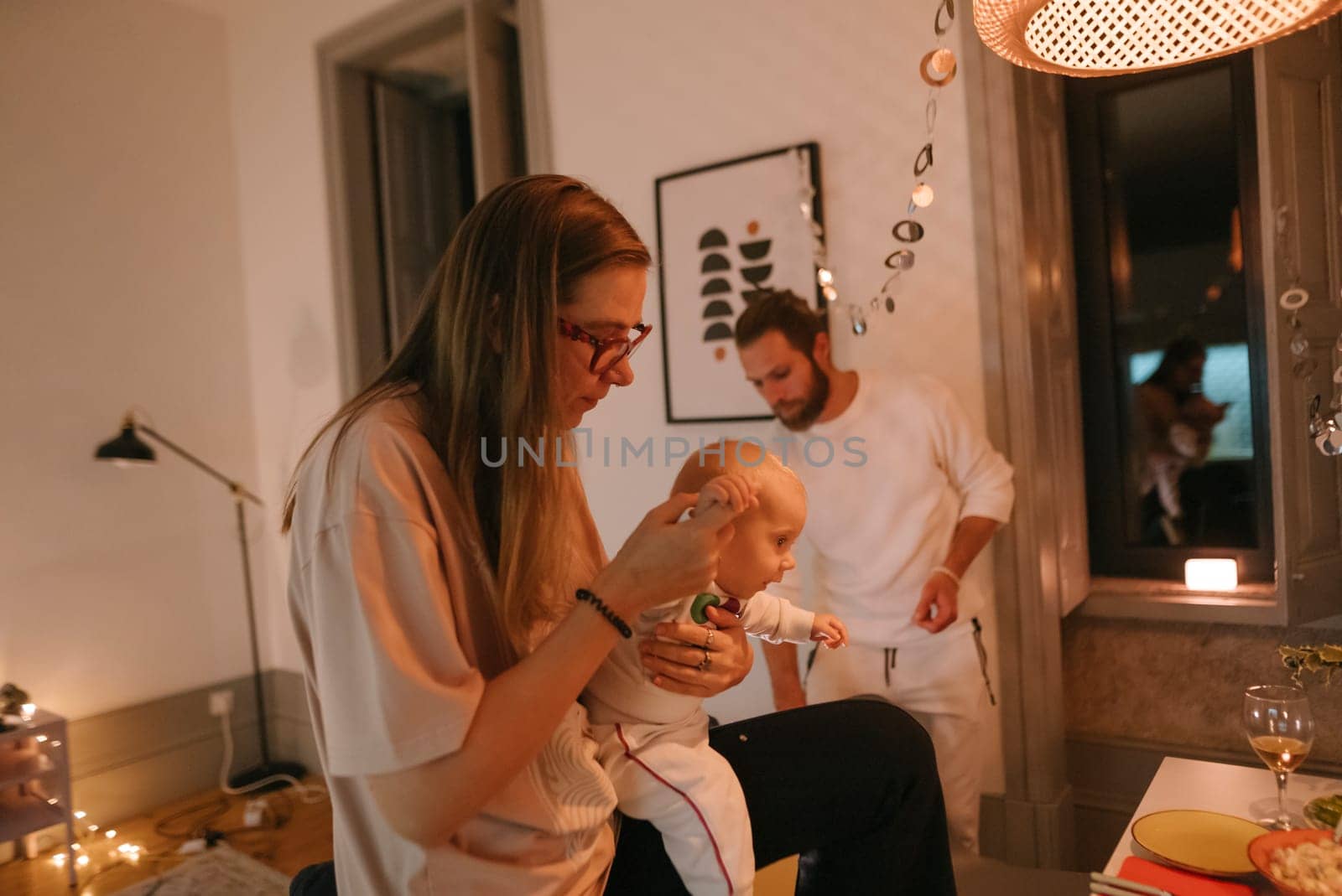 A lovely and warm evening scene displays a happy family enjoying precious quality time spent with their baby