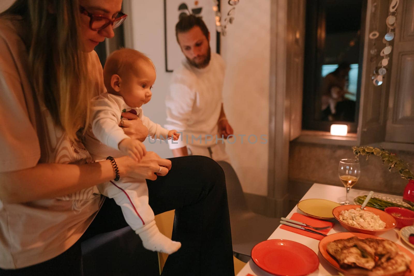 A warm and inviting family dinner that features a beloved baby and freshly prepared, delicious meals on the table