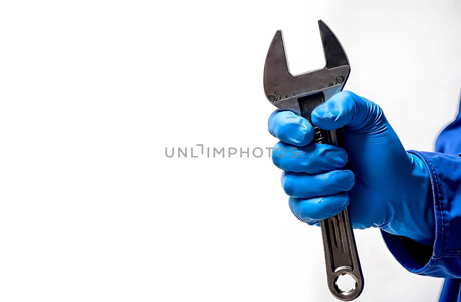 A technician in blue gloves holds an adjustable wrench, preparing to perform maintenance work in a workshop environment.