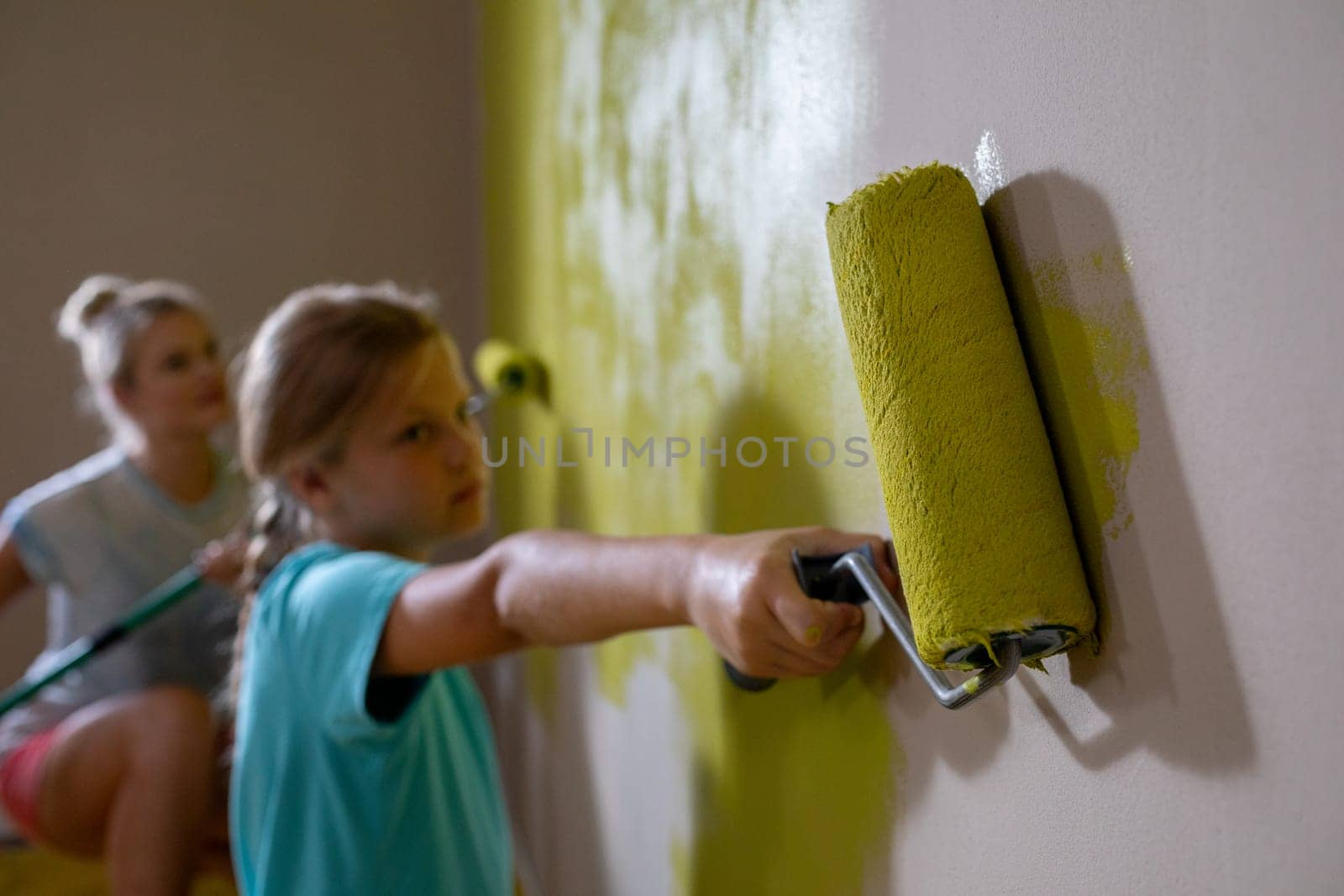 Two kids joyfully paint a wall bright yellow, capturing the essence of creativity and funfilled expression