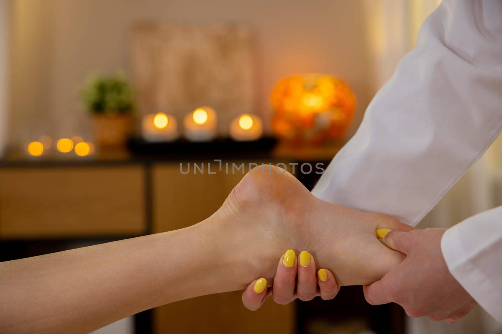 Immerse yourself in tranquility as you enjoy a soothing foot massage within a serene, candlelit setting