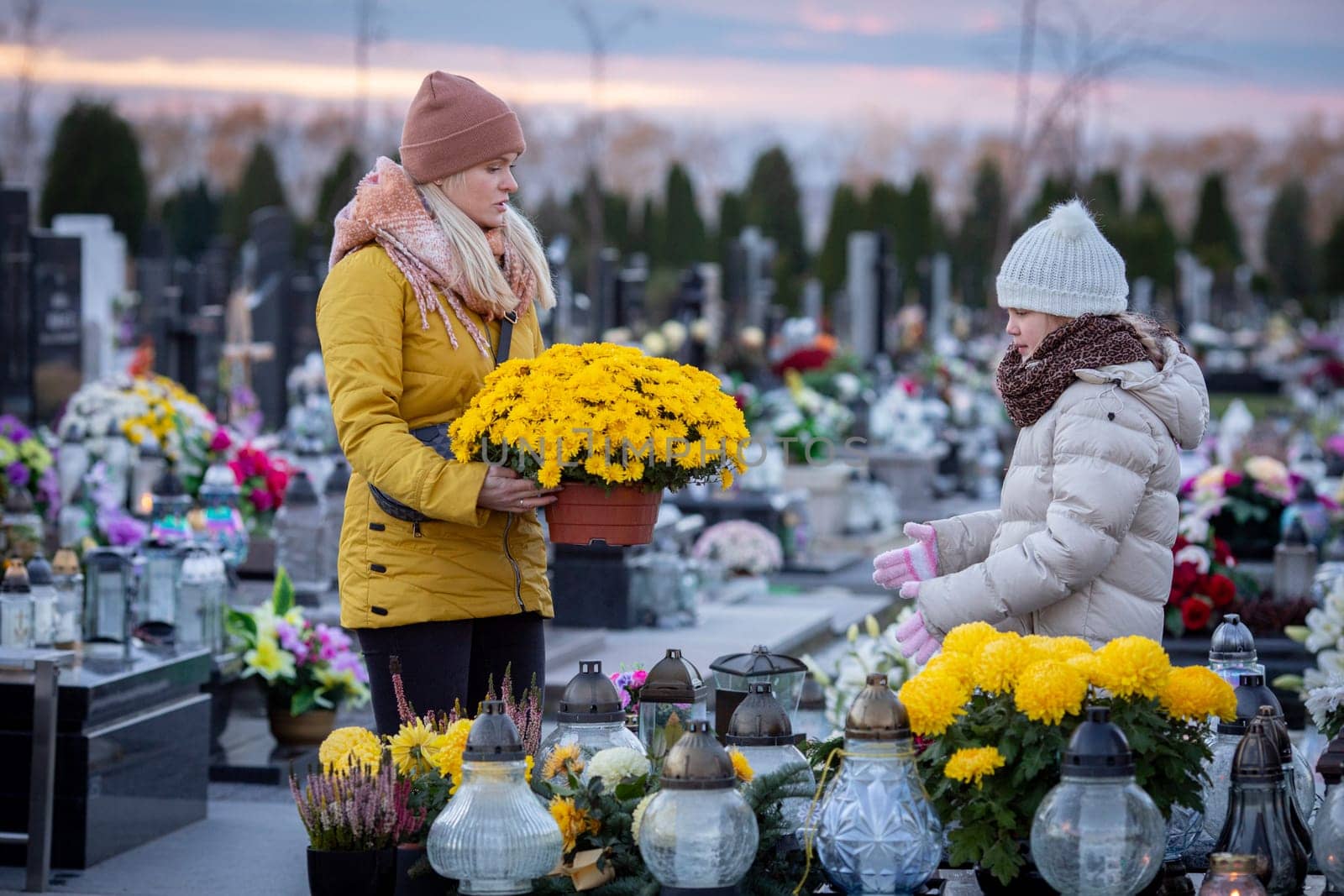 A truly heartfelt moment of remembrance takes place at a beautiful cemetery adorned with flowers and glowing lanterns