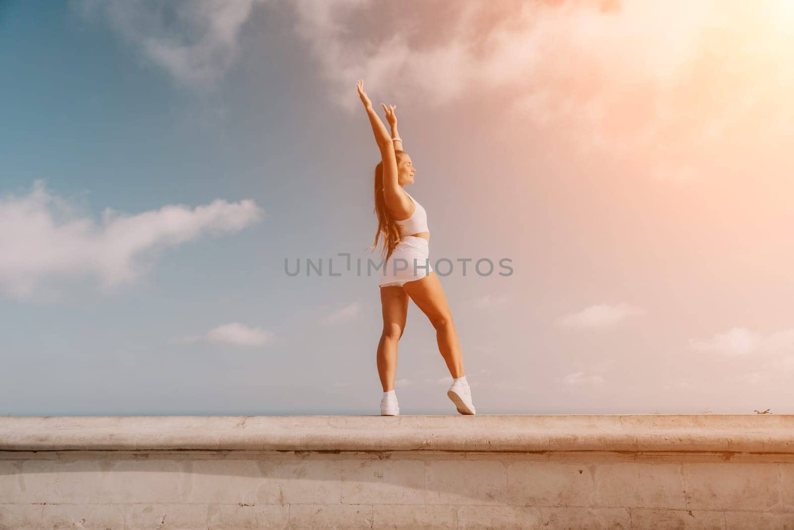 Fitness woman sea. Outdoor workout on yoga mat in park near to ocean beach. Female fitness pilates yoga routine concept. Healthy lifestyle. Happy fit woman exercising with rubber band in park.