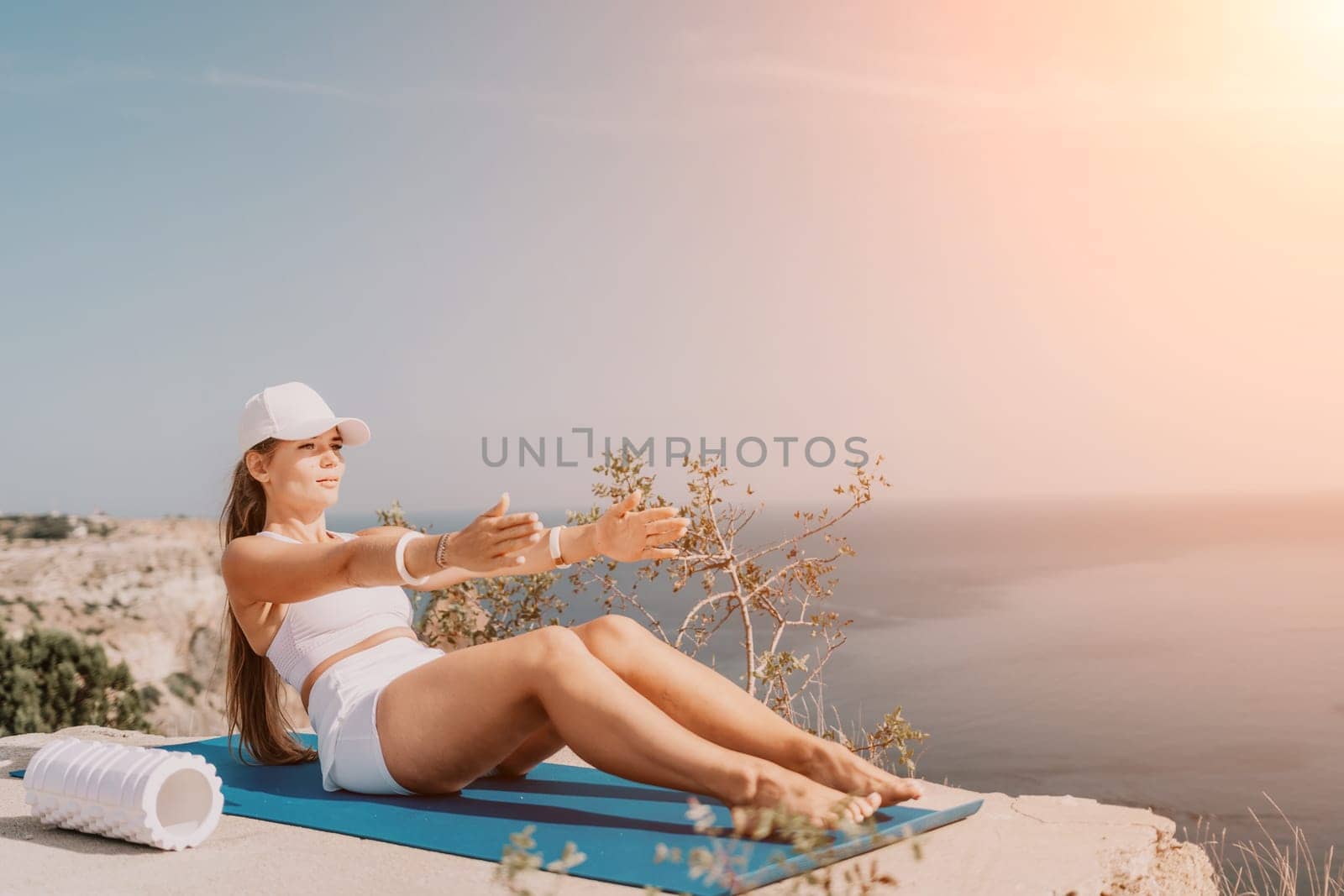 Fitness woman sea. Outdoor workout on yoga mat roller in park near to ocean beach. Female fitness pilates yoga routine concept. Healthy lifestyle. Happy fit woman exercising with rubber band in park. by panophotograph