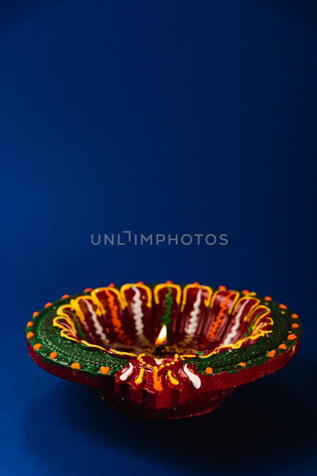 Diwali joy captured in the glow of colorful clay diya lamps, signifying prosperity and happiness, set against a calming blue background. Ideal for greeting cards and religious ceremonies.