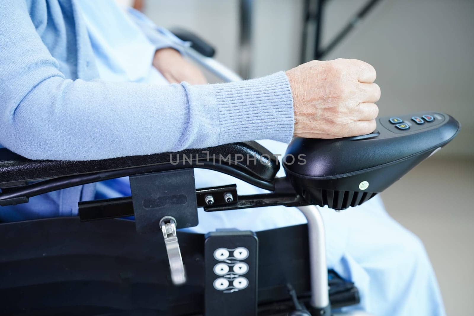 Asian elderly woman disability patient sitting on electric wheelchair in park, medical concept.