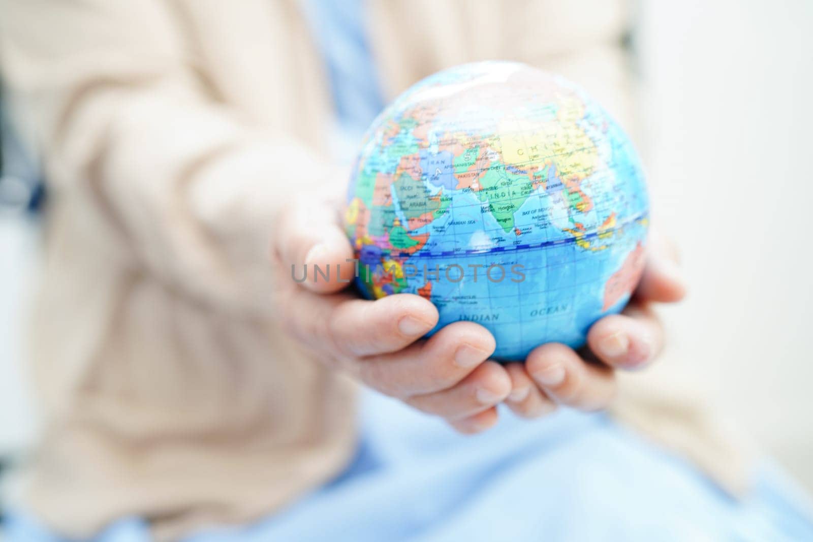 Bangkok, Thailand April 1, 2023 Asian elderly woman patient holding globe in hand at hospital.