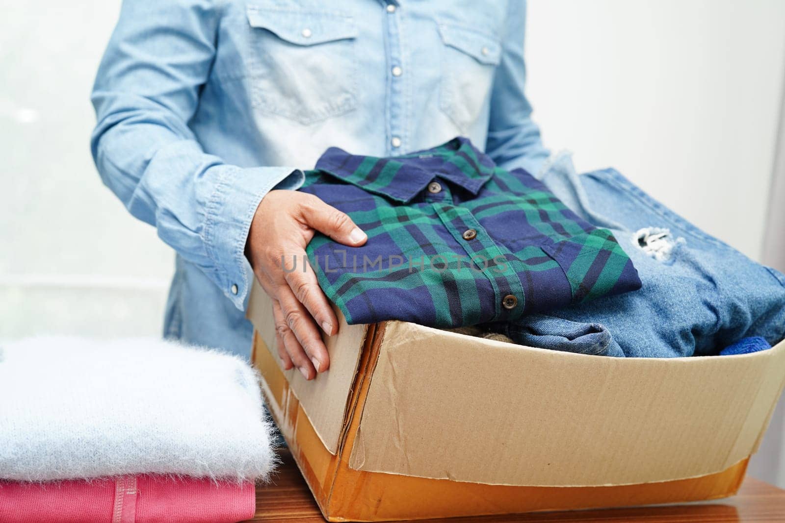 Clothes donations in cardboard box for volunteer.