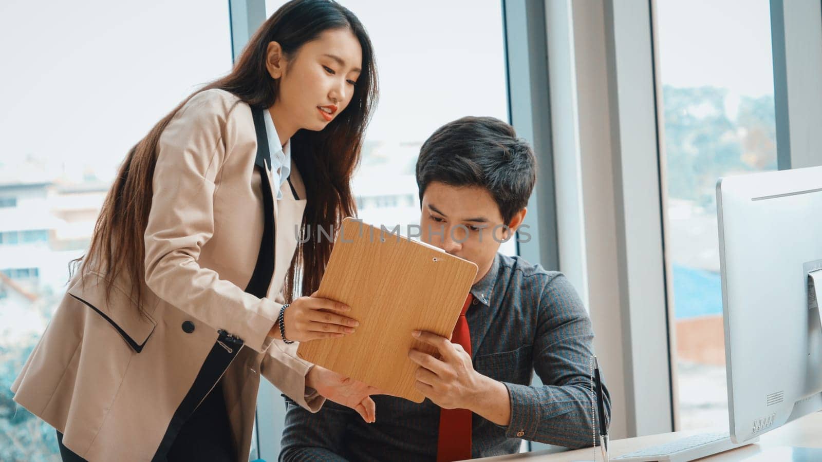 Two business people talk project strategy at office meeting room. Businessman discuss project planning with colleague at modern workplace while having conversation and advice on financial report. Jivy