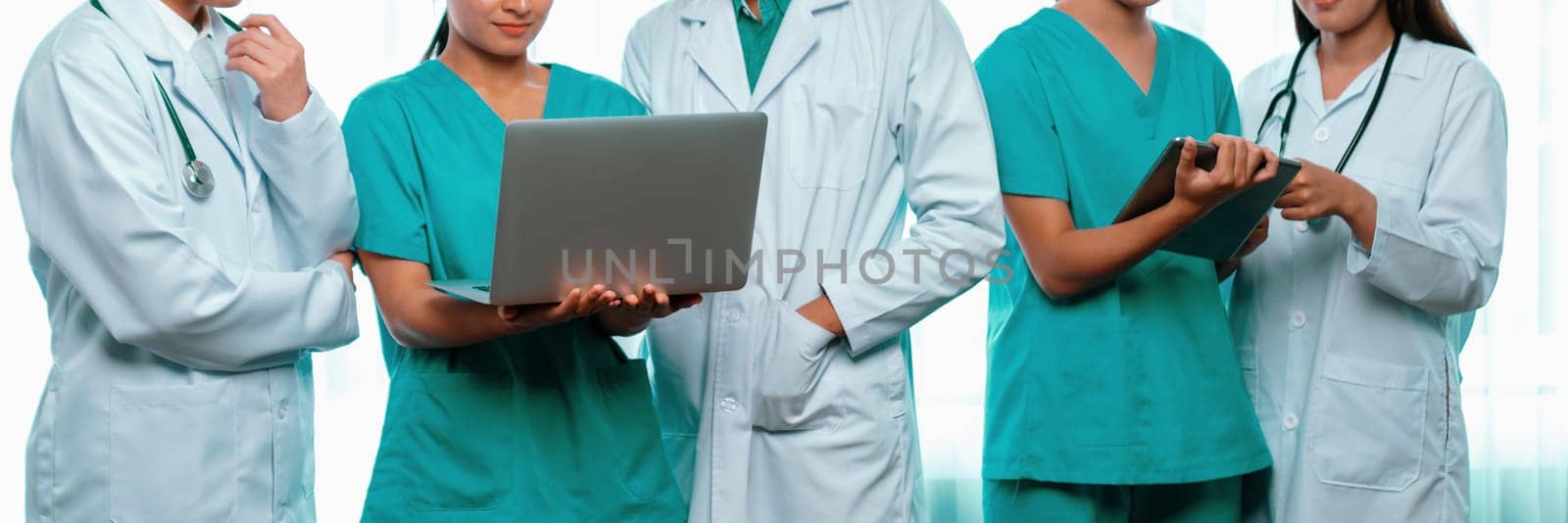 Medical staff team with doctor nurse and healthcare specialist professions working together with laptop and tablet in hospital. Medical workplace and healthcare community in panoramic banner. Neoteric