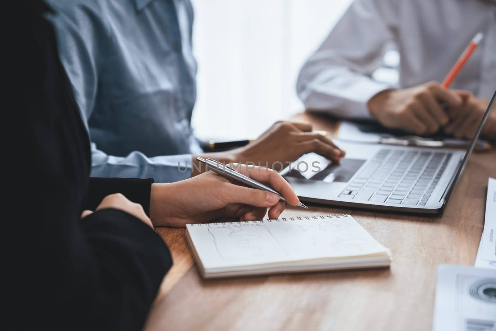 Diverse business people work together, discuss in corporate office. Professional teamwork discussing and pointing at laptop. Modern multicultural office worker. Concord