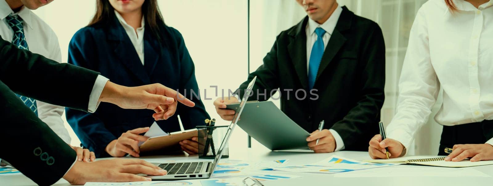 Business people in group meeting in formal attire share idea discussing report for company profit in creative workspace for start up business shot in close up view on group meeting table . Oratory .