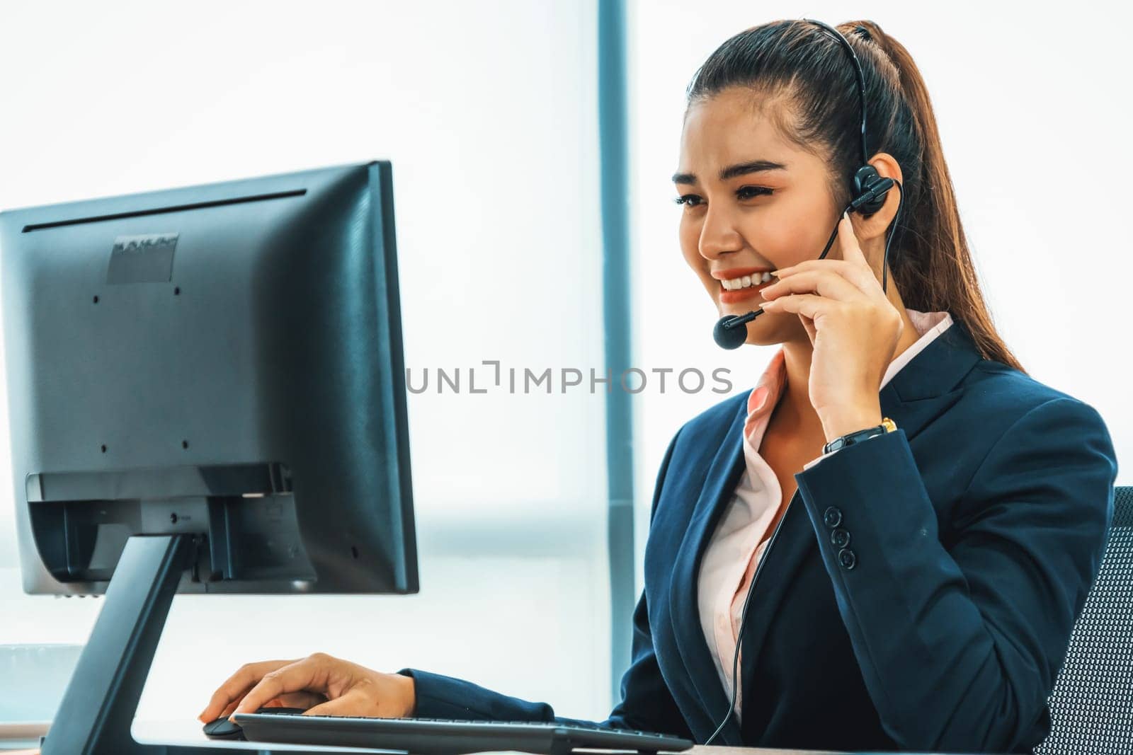 Business people wearing headset working in office to support remote customer or colleague. Call center, telemarketing, customer support agent provide service on telephone video conference call. Jivy