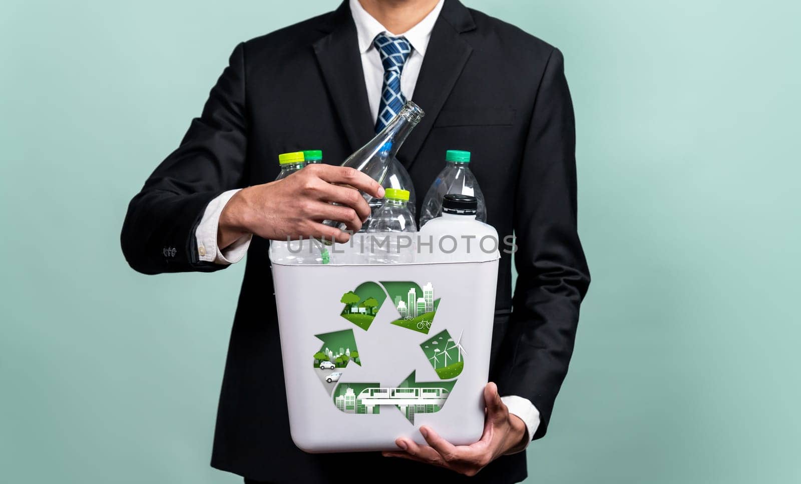 Eco friendly business with ESG commitment to make greener campaign with corporate recycling and waste management. Businessman hold recycle bin promoting sustainable clean environment. Reliance