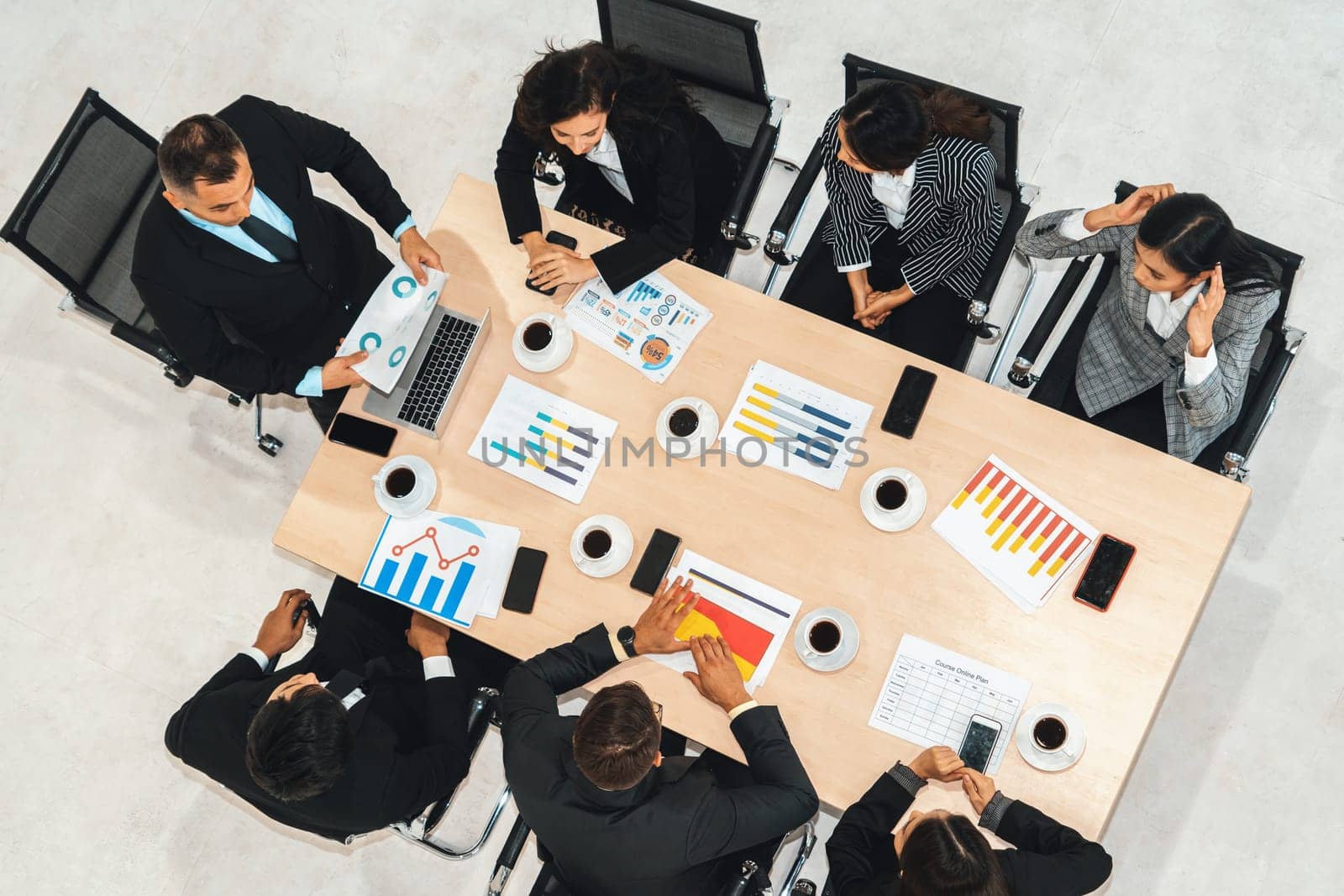 Business people group meeting shot from top view in office . Profession businesswomen, businessmen and office workers working in team conference with project planning document on meeting table . Jivy