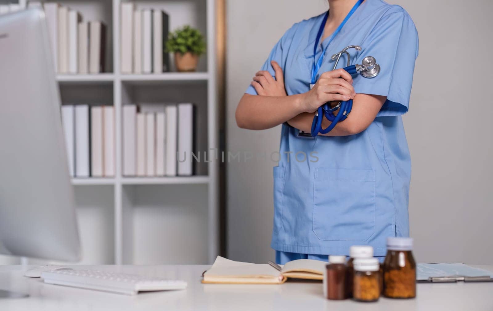 Close up a doctor standing with his arms crossed holding a stethoscope, a doctor from the hospital. Medical staff people. Team of doctor and nurse in hospital. Concept Of Medical by wichayada
