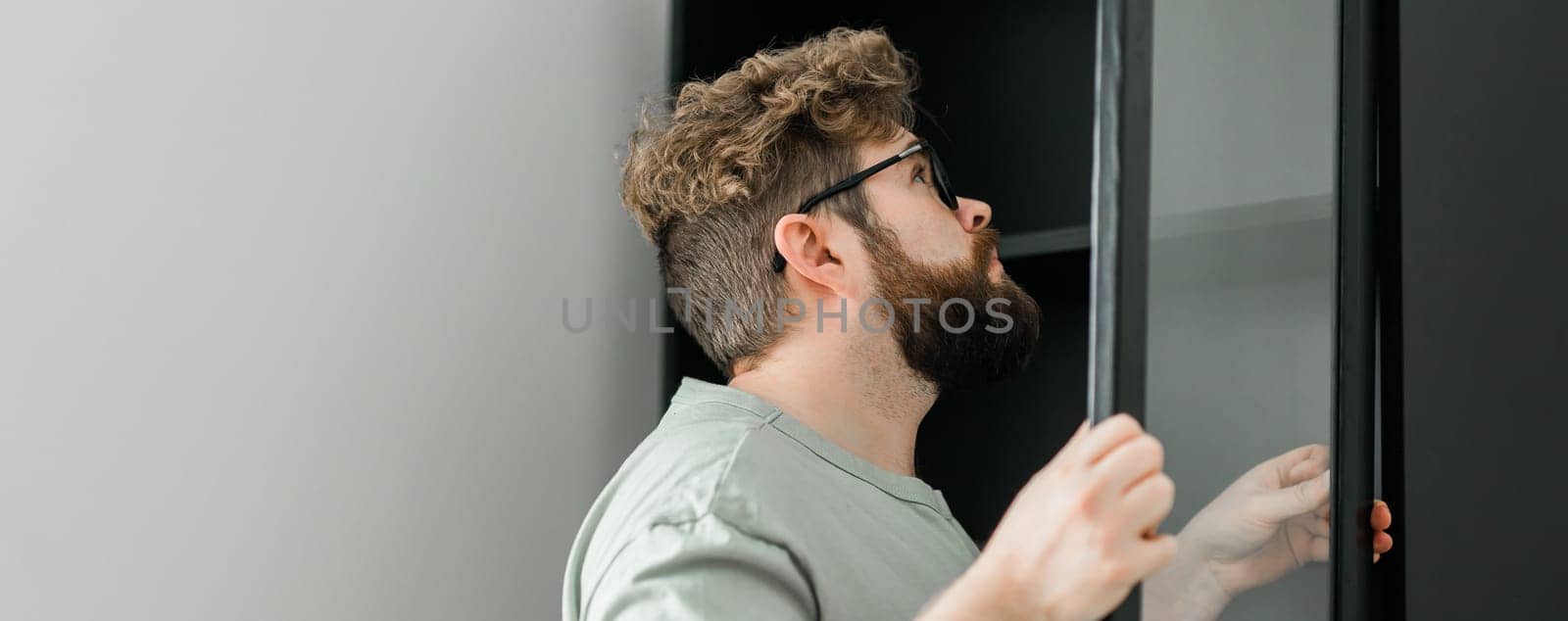 Banner portrait of man assembling furniture copy space. Do it yourself furniture assembly at home by Satura86