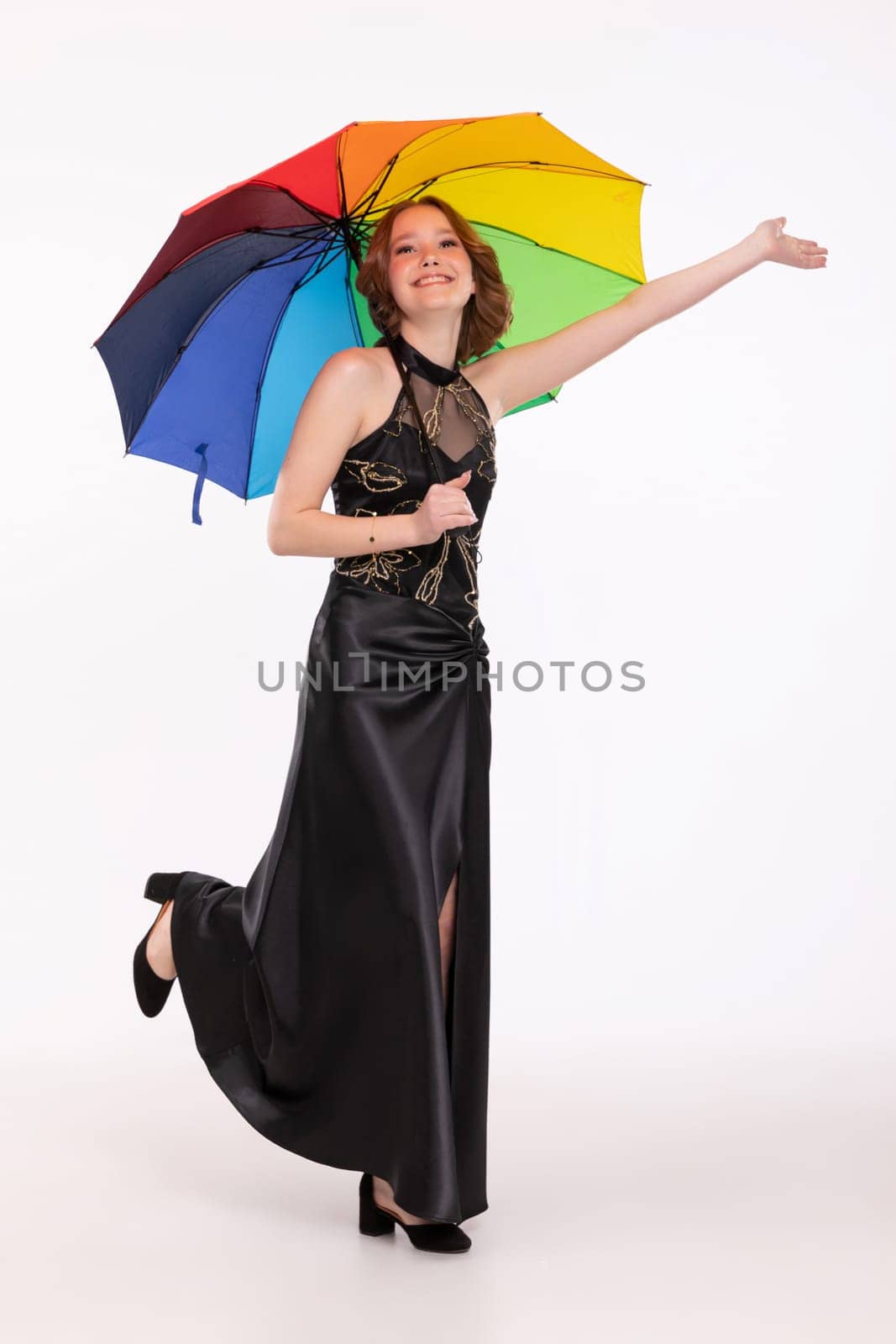 A vibrant photo shows a woman in a sleek black dress joyfully holding a colorful umbrella, radiating happiness