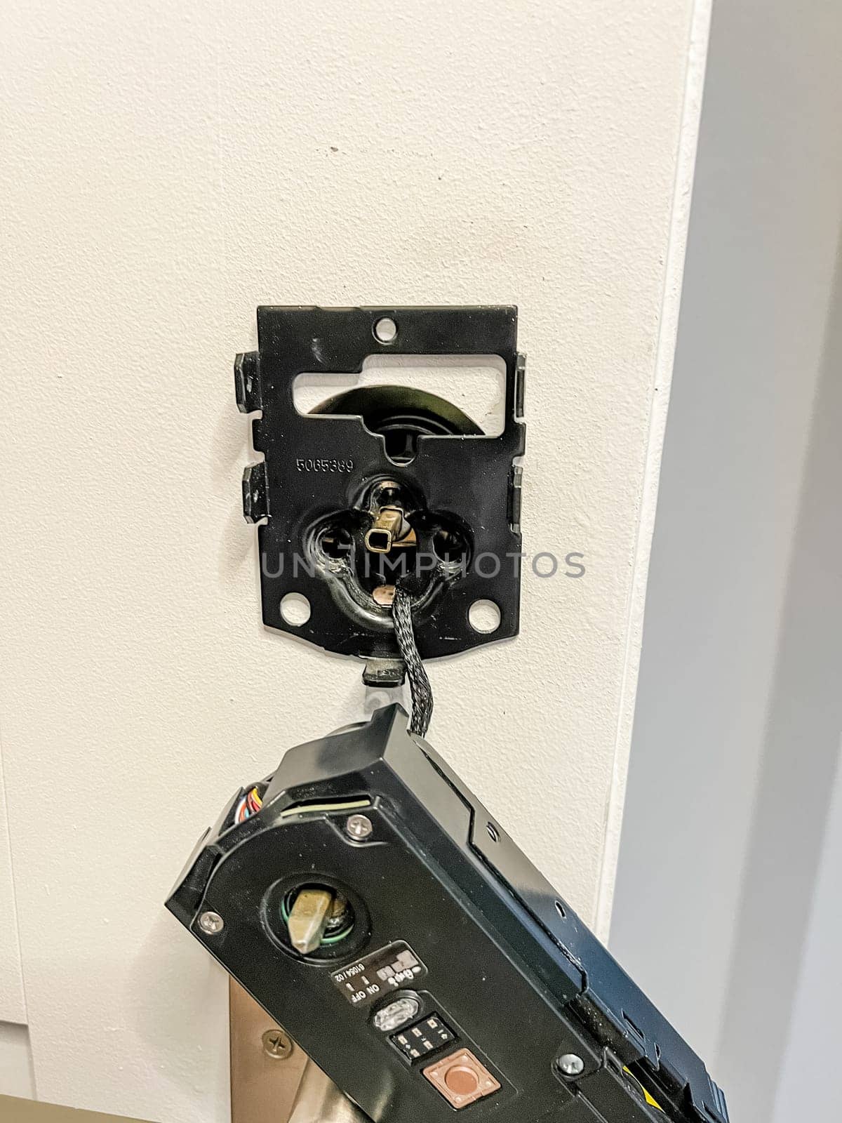 Castle Rock, Colorado, USA-November 23, 2023-A close-up view of the installation of a smart electronic door lock on a white interior door. The person is connecting the wiring and securing the lock mechanism, ensuring proper functionality for keyless entry and enhanced home security. This process is part of a home improvement project to modernize access control.