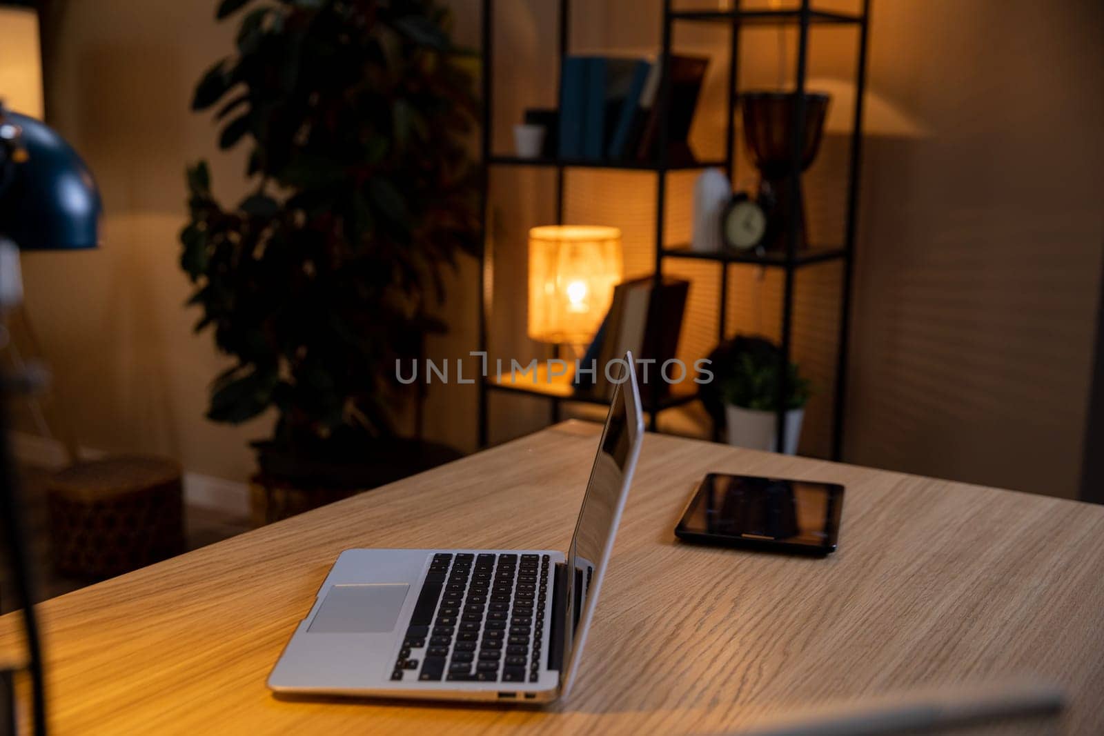 Aesthetic home office with a laptop, tablet, and warm lighting to boost productivity and creativity