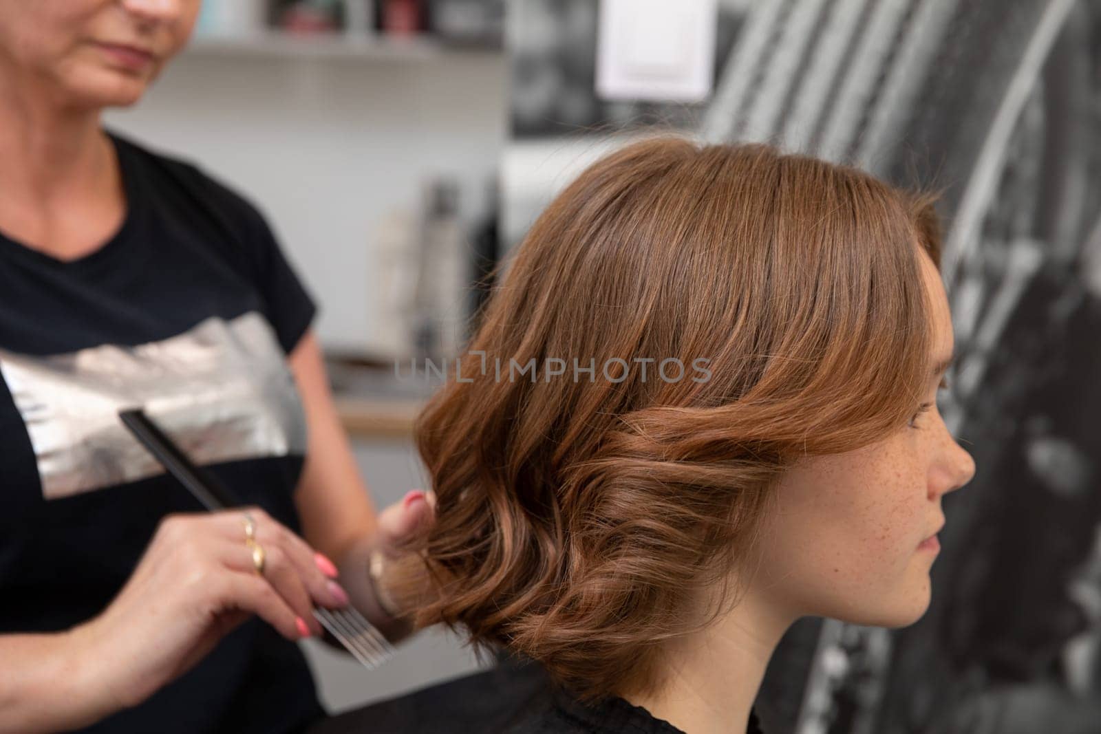 A skilled stylist gives a trendy haircut to a fashionable young woman, showcasing the latest hair trends