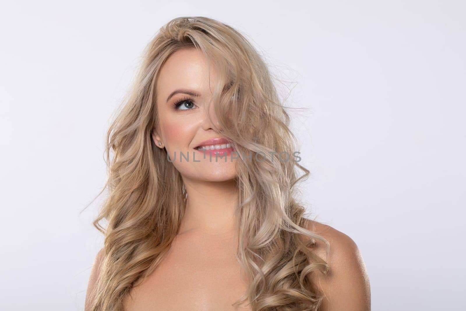 A stunning and captivating woman with long, flowing blonde curls, radiating elegance, beauty, and undeniable confidence