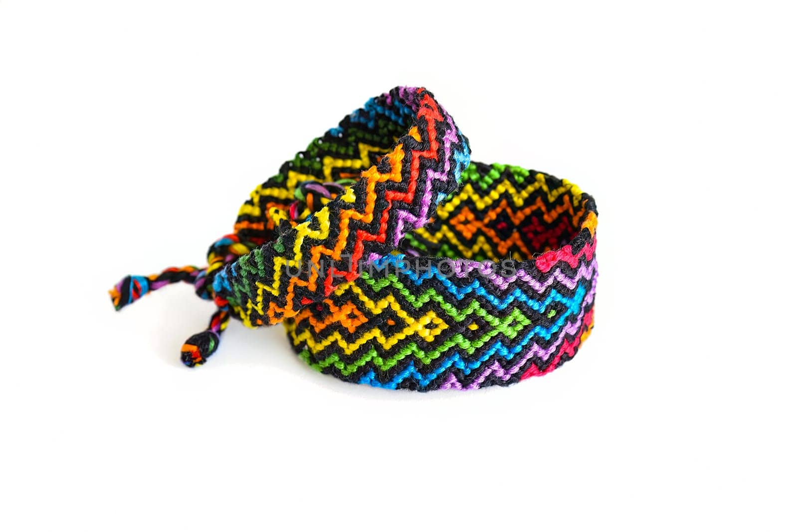 Multicolored woven DIY friendship bracelets handmade of embroidery bright thread with knots isolated on white background