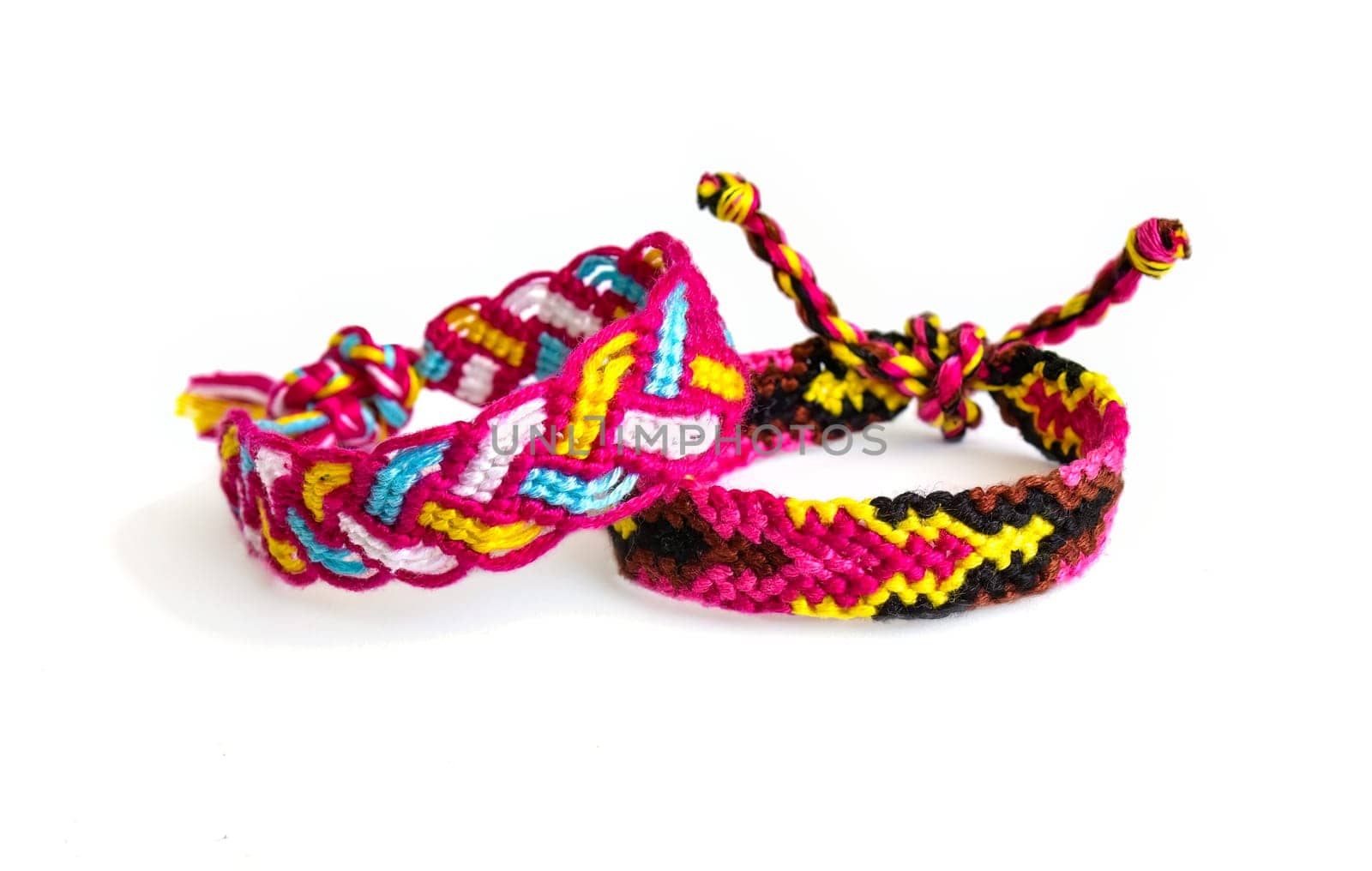 Multicolored woven DIY friendship bracelets handmade of embroidery bright thread with knots isolated on white background