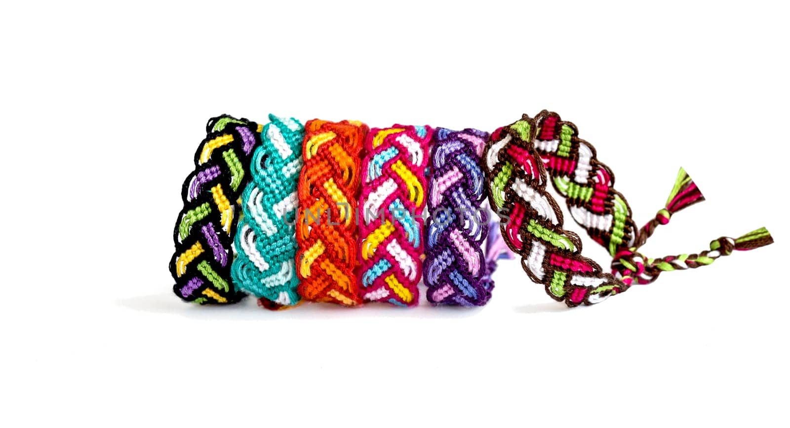 Multicolored woven DIY friendship bracelets handmade of embroidery bright thread with knots isolated on white background