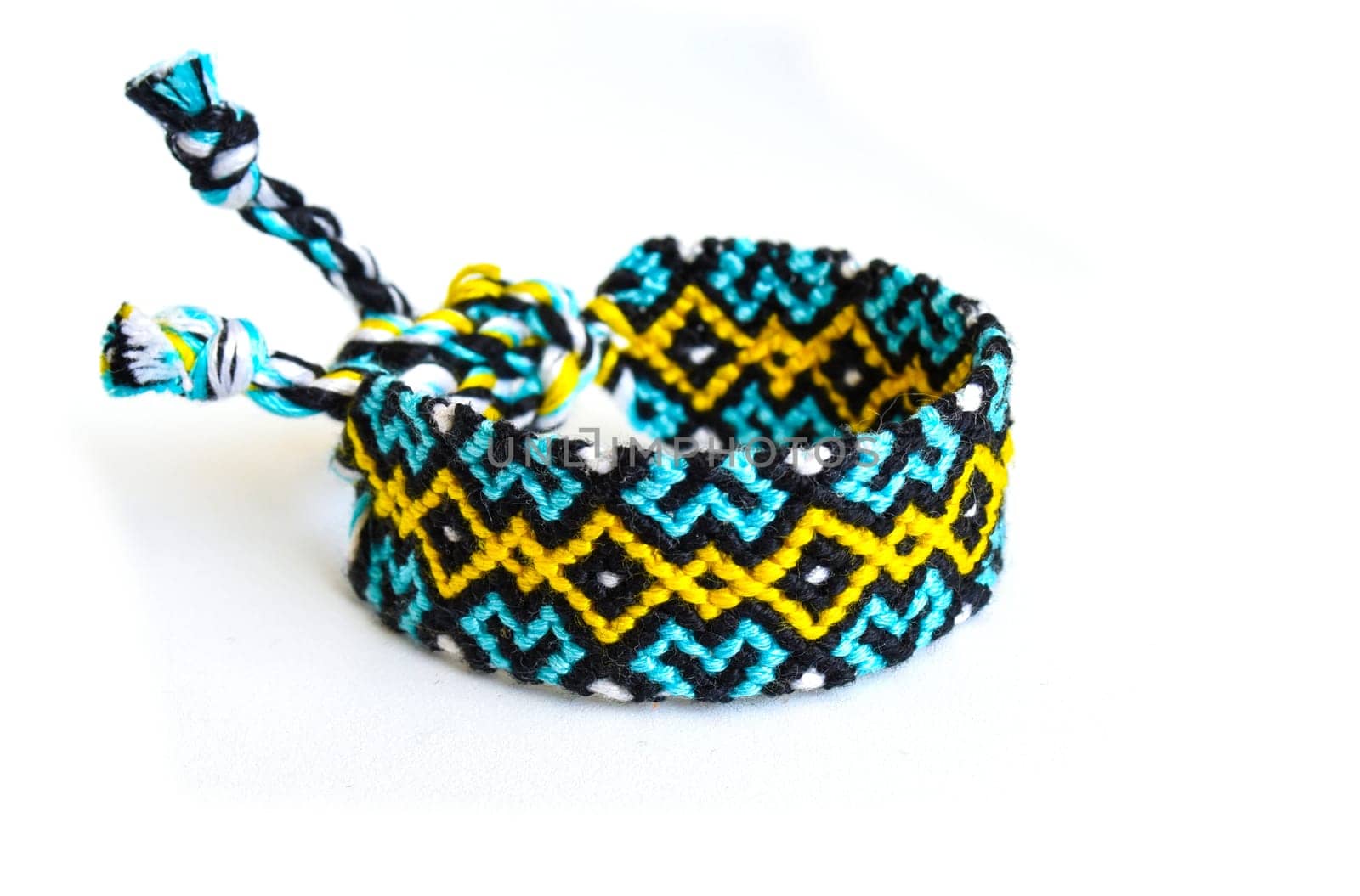 Multicolored woven DIY friendship bracelets handmade of embroidery bright thread with knots isolated on white background